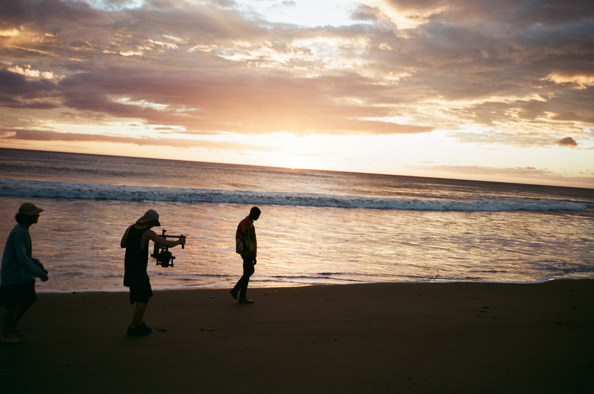 Vincent Ruel-Cote from Les Gamins filming singer Karim Ouellet walking on the beach at sunset for music video of La Mer A Boire
