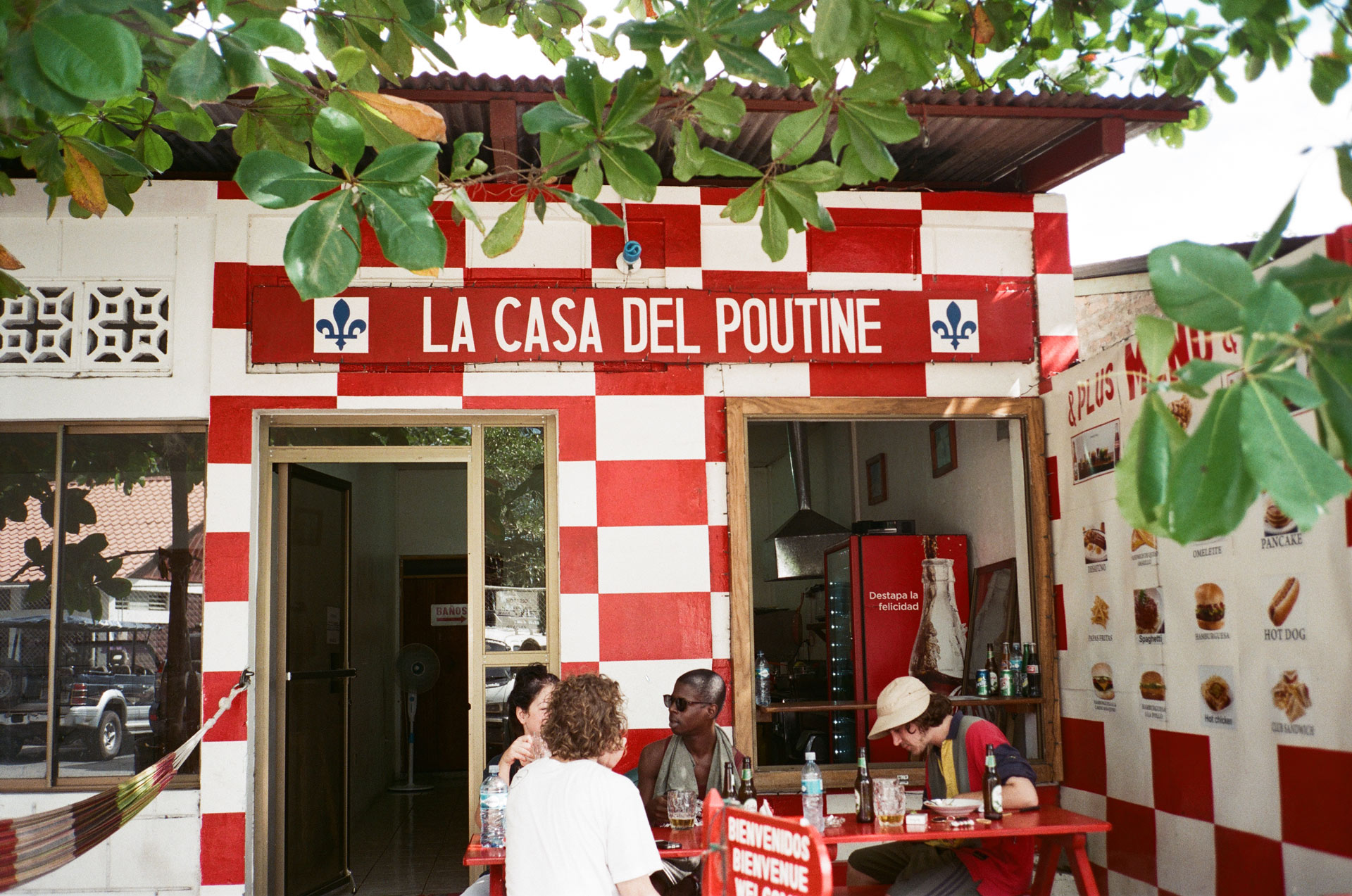 Vincent Ruel-Cote and Marco Gilbert from Les Gamins with singer Karim Ouellet and filming crew eating at restaurant called "La casa del poutine" while filming for music video of La Mer A Boire