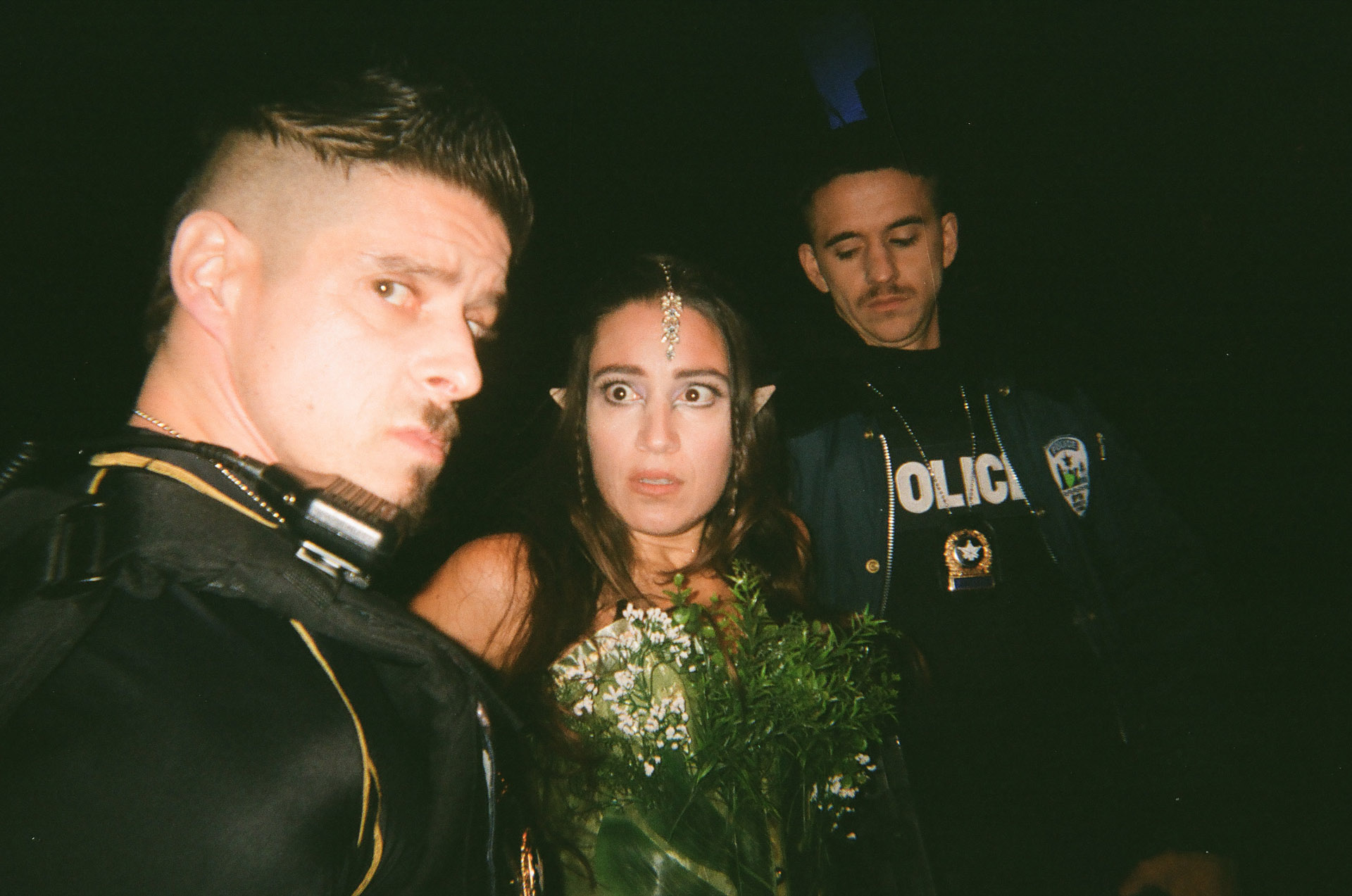 actors Hugolin Chevrette-Landesque and Emile Schneider dressed as cops on each side of woman dressed as elf in behind the scenes for TV series La Loi C'est La Loi filmed by Les Gamins for TV5 Unis