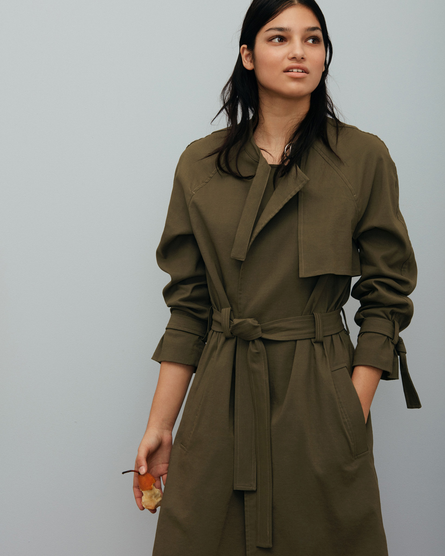 woman in dark green outfit on light blue background by Maxyme G Delisle for The Ones 2 Watch
