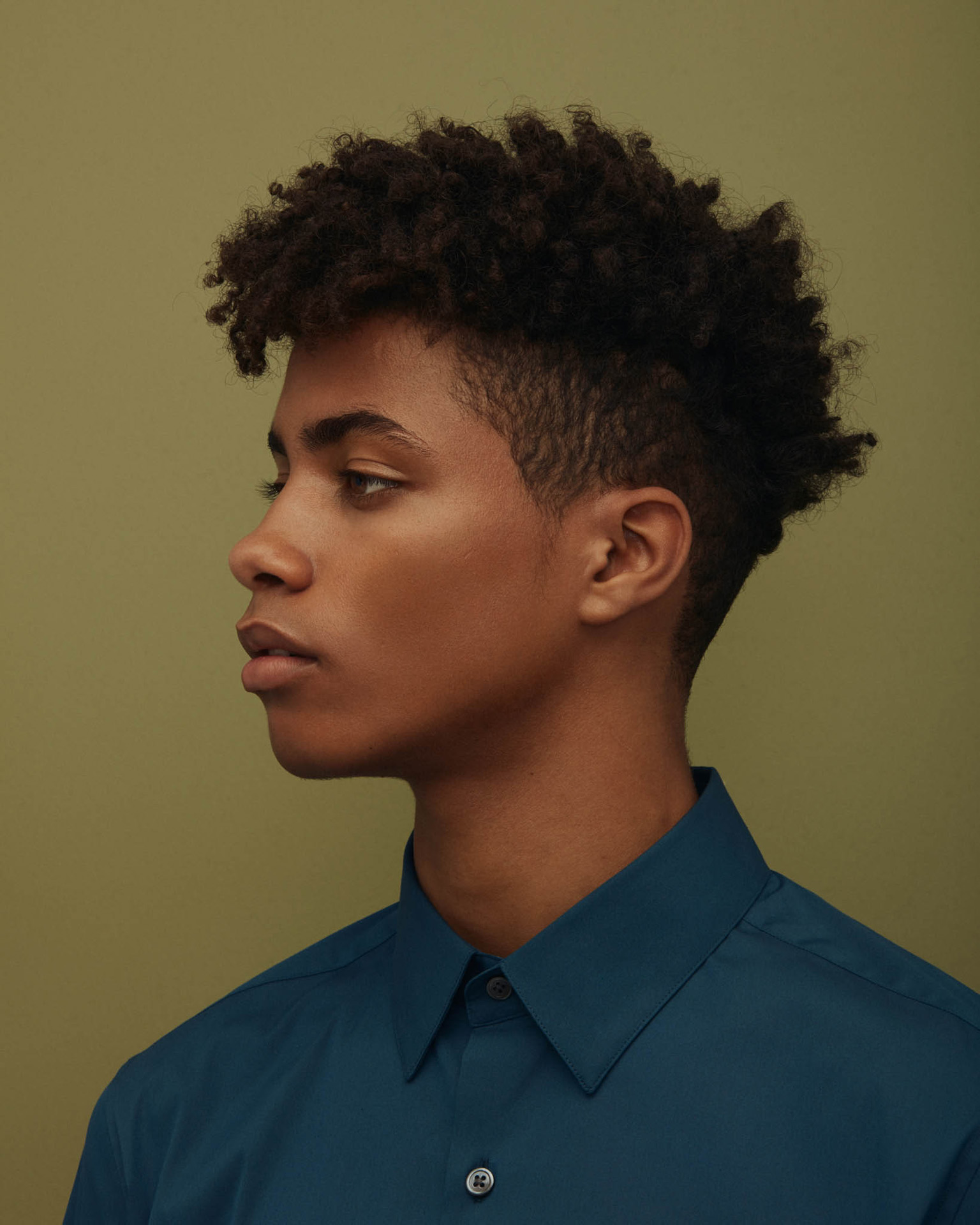 black man in dark blue shirt on green background by Maxyme G Delisle for The Ones 2 Watch