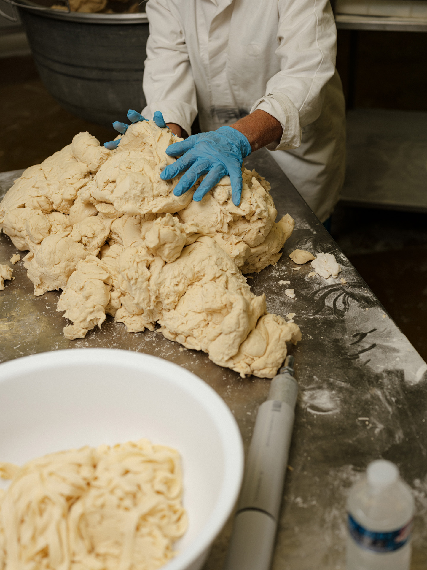 worker kneading pasta dough by Alexi Hobbs in Auvergne for Reflets de France