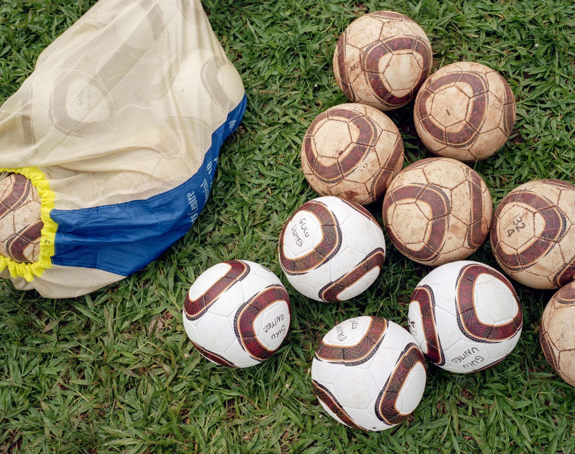 picture of tattered and new soccer balls side by side on the ground by Alexi Hobbs in Uganda for Football for Good with Sportsnet