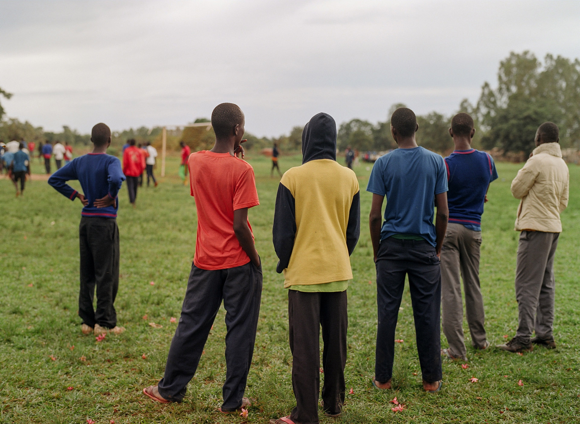 group of boys watching soccer match from the sidelines by Alexi Hobbs in Uganda for Football for good with Sportsnet