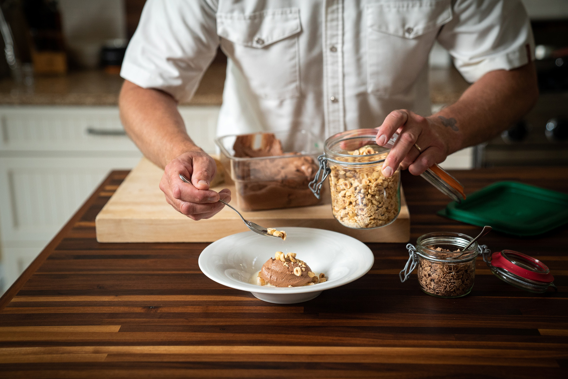 chef Michael Allemeier topping bowl of coffee mousse with roasted hazelnuts by Bruno Florin for Van Houtte 100th anniversary
