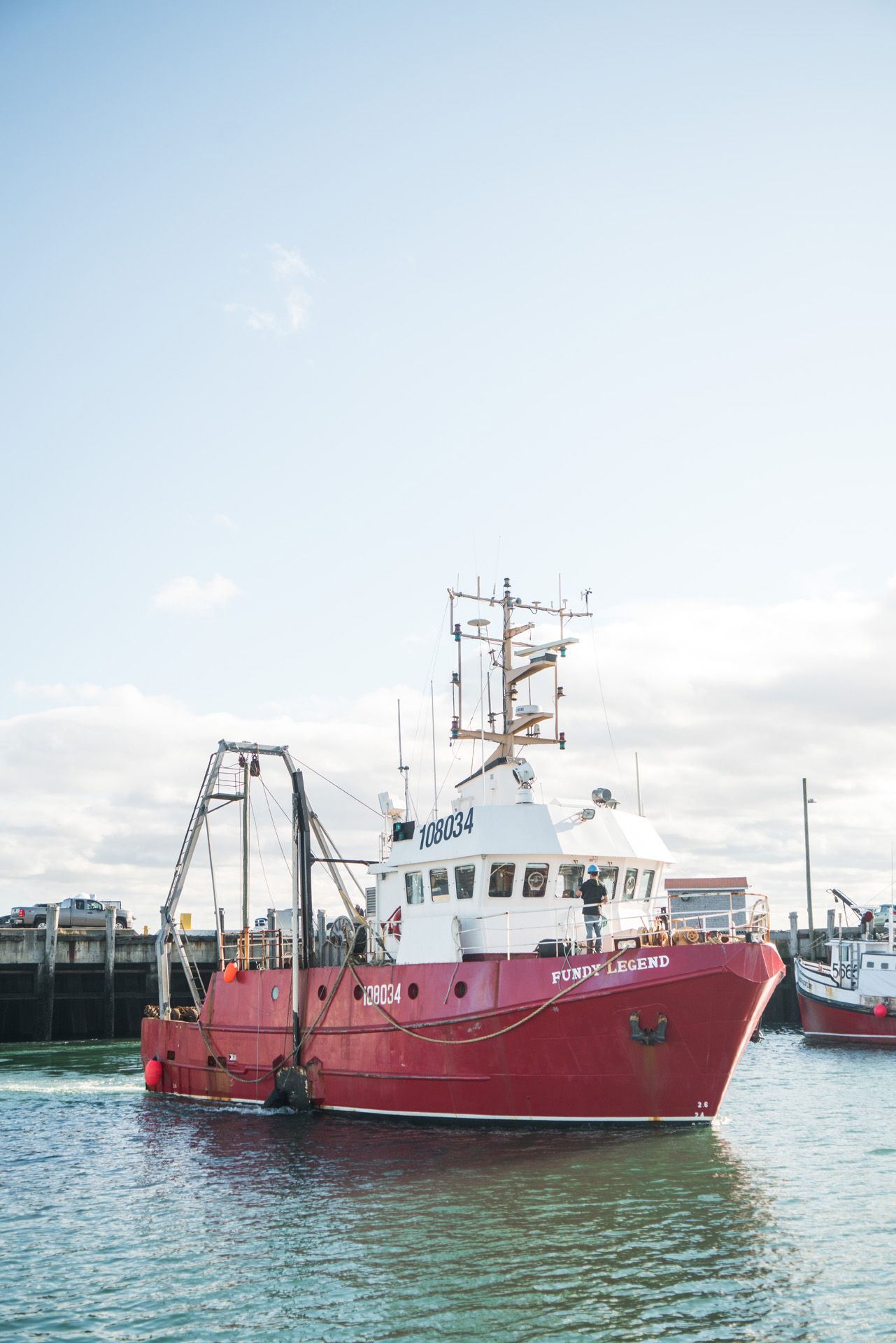 red fishing boat in the port by Bruno Florin for Ricardo Magazine in Bay of Fundy