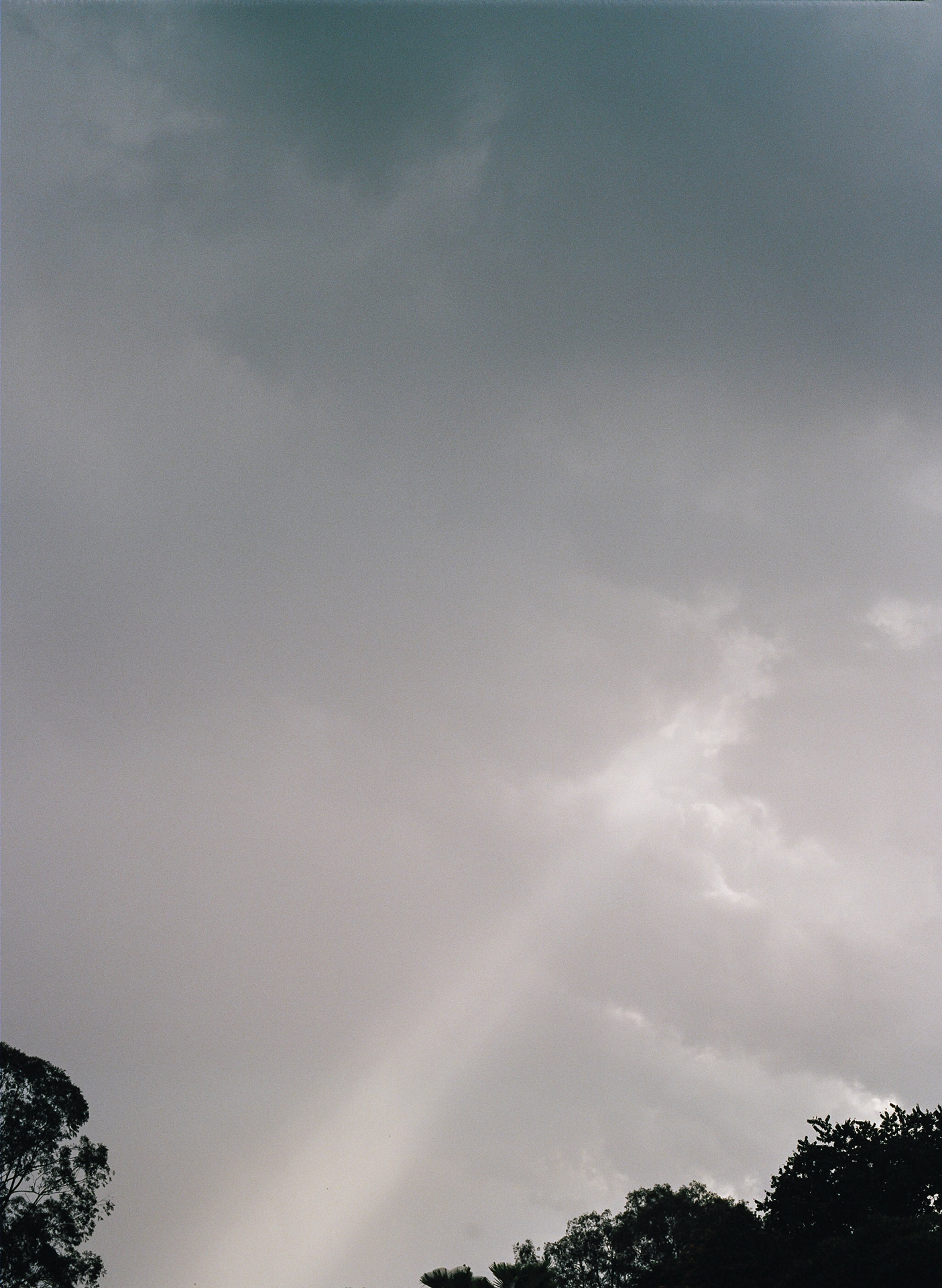 ray of light piercing through grey clouds in the sky by Alexi Hobbs in Uganda for Football for Good with Sportsnet