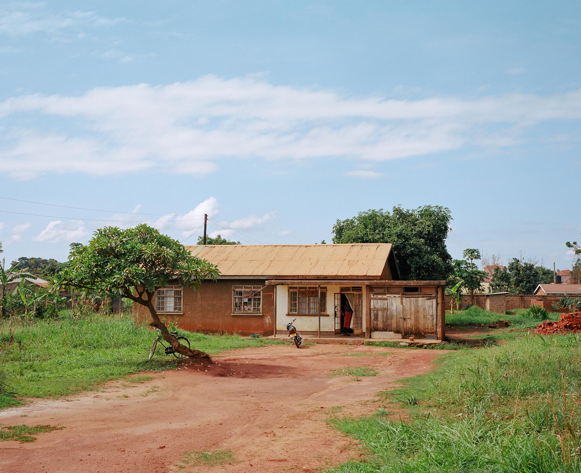 simple brown house made of dirt and metal sheets by Alexi Hobbs in Uganda for Football for Good with Sportsnet
