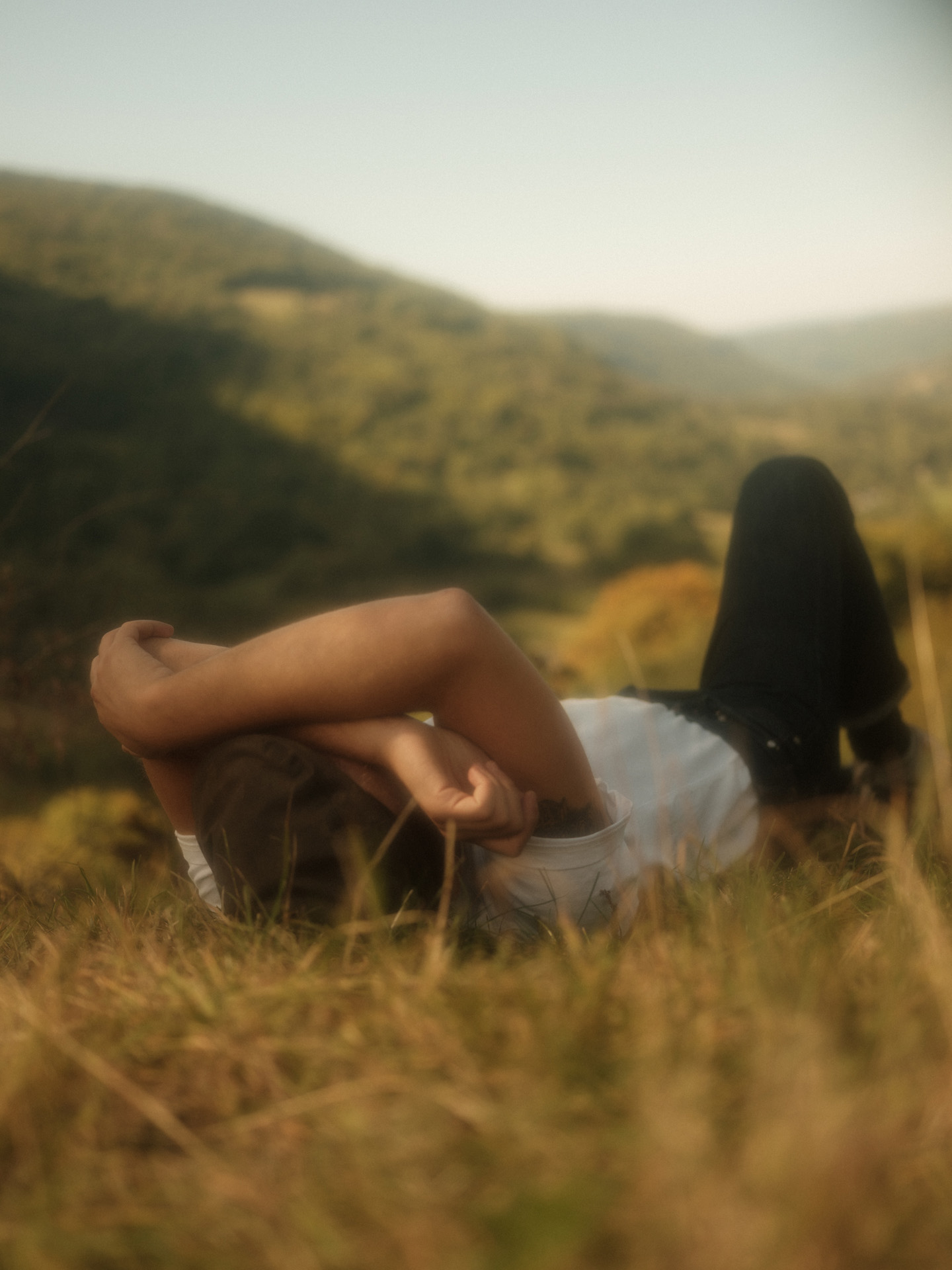 man laying down in grass by Alexi Hobbs in Auvergne for Reflets de France