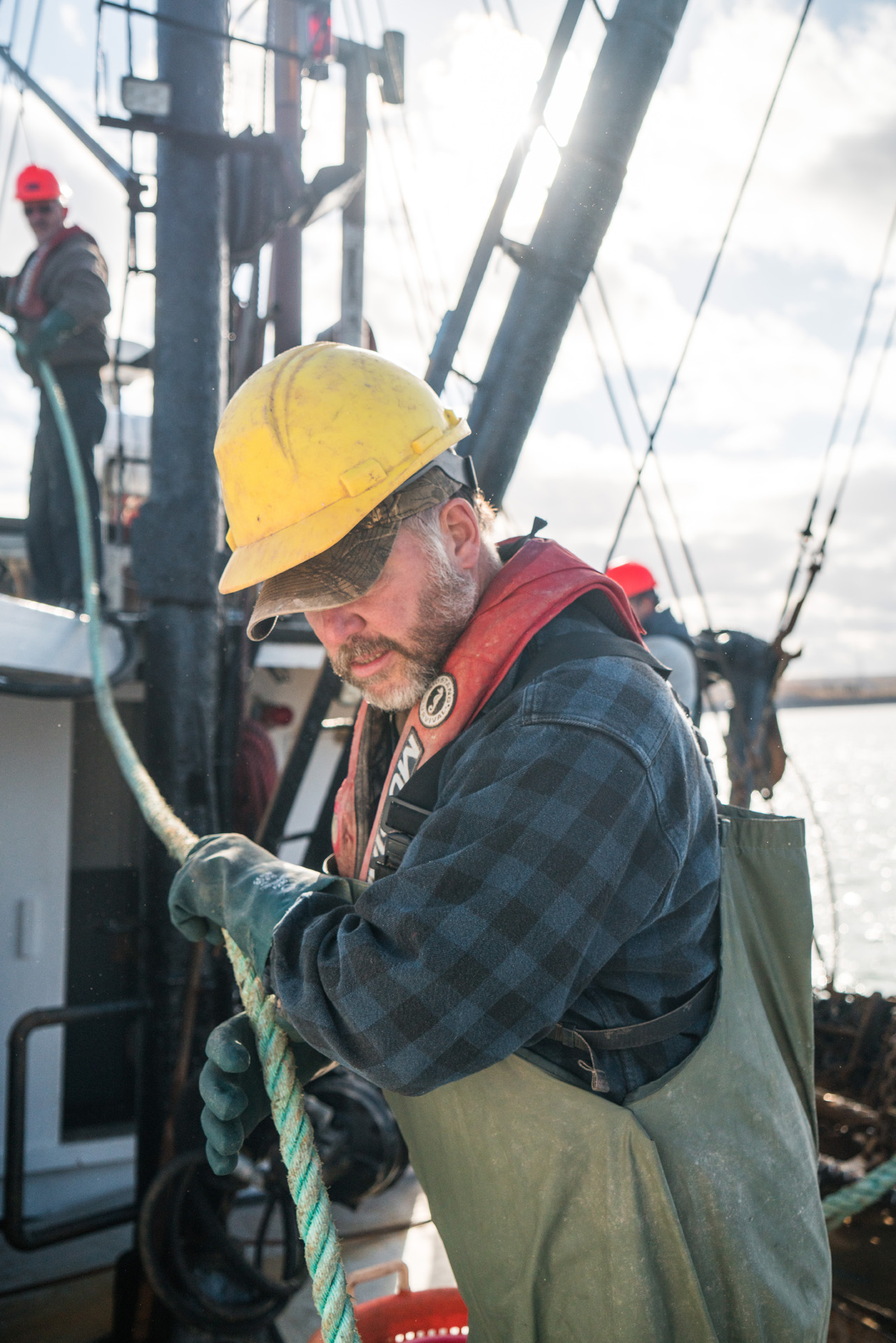 fisherman wearing yellow helmet holding rope by Bruno Florin for Ricardo Magazine in Bay of Fundy