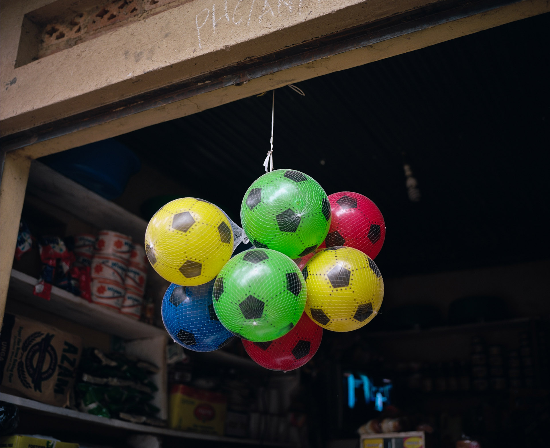 bunch of suspended plastic soccer balls by Alexi Hobbs in Uganda for Football for good with Sportsnet