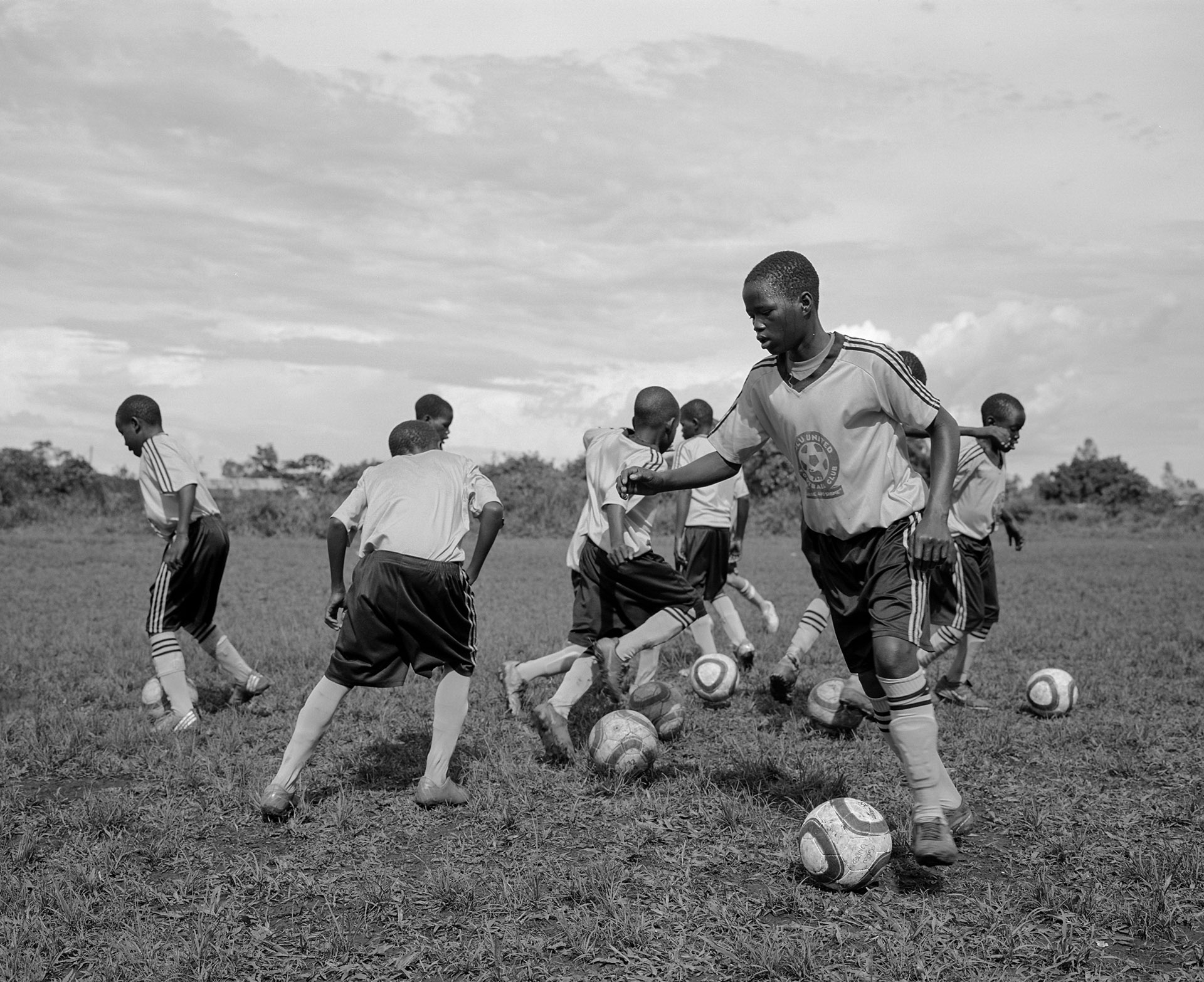 young black soccer players practicing their kicks in black and white by Alexi Hobbs in Uganda for Football for good with Sportsnet