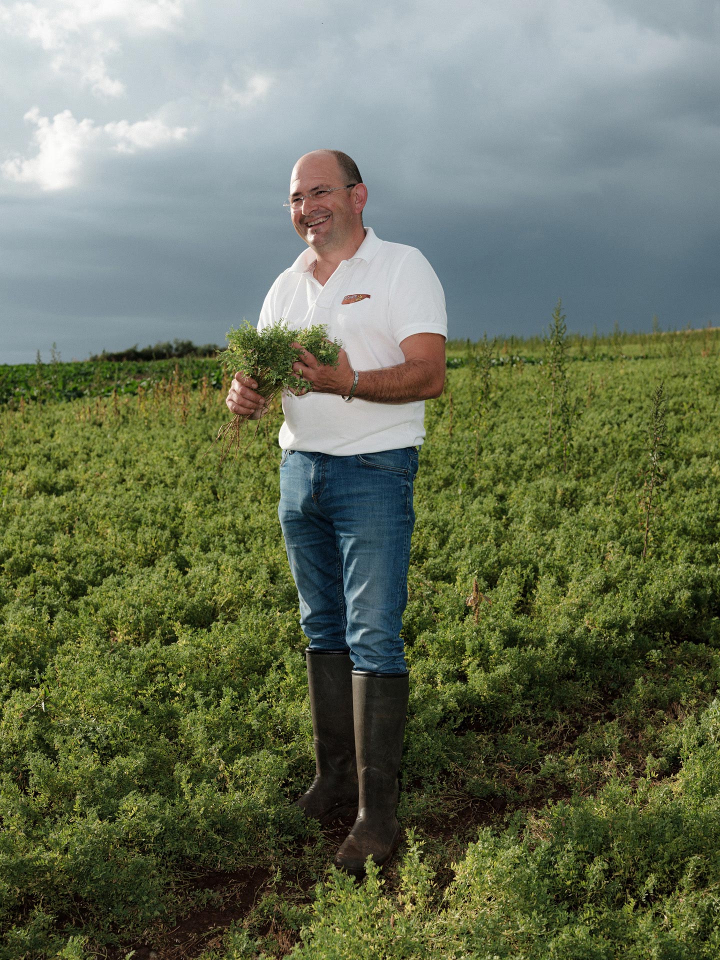 farmer man in his field laughing showing off his crop by Alexi Hobbs in Auvergne for Reflets de France