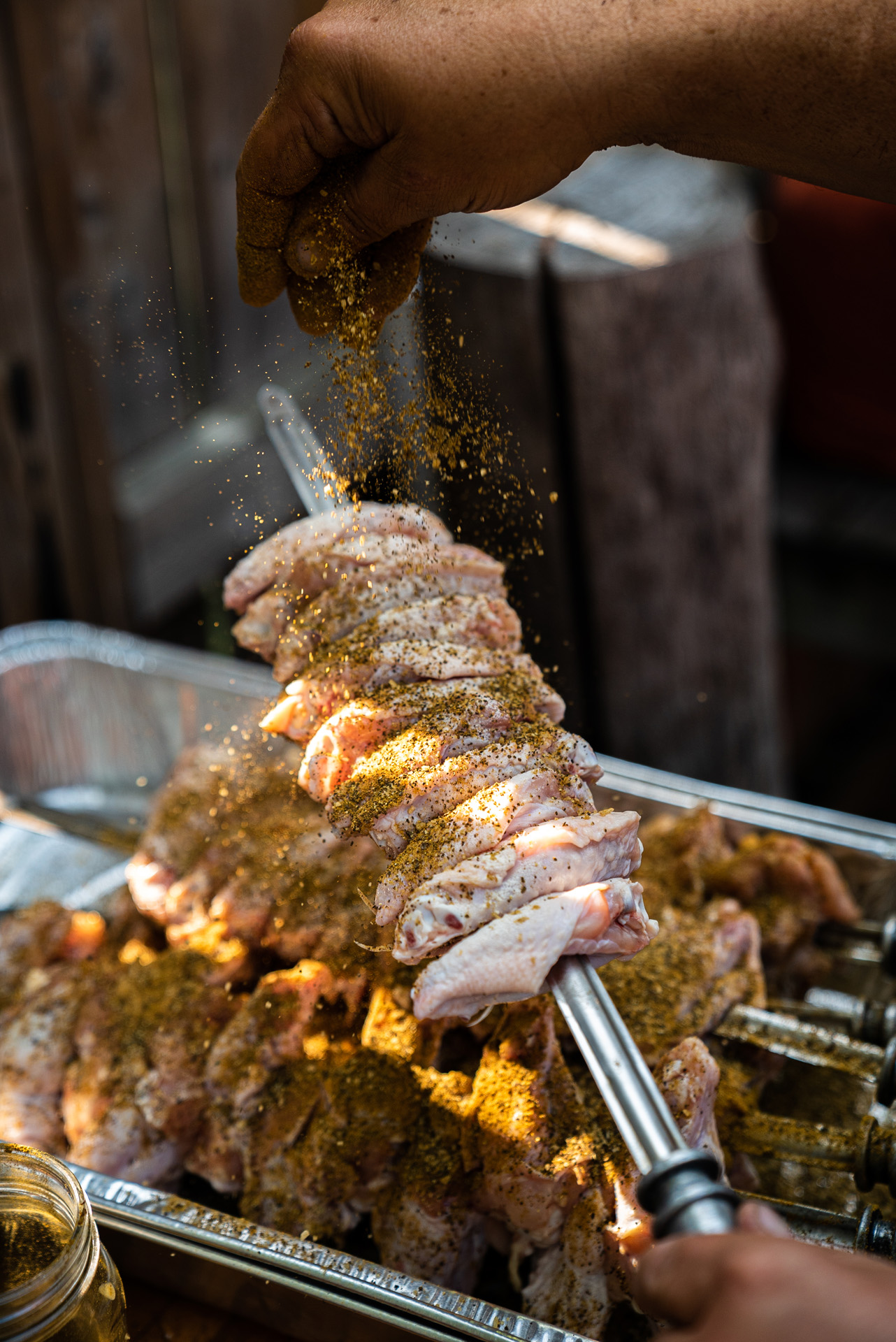 chef Ted Reader covering chicken wings on skewers in spices by Bruno Florin for Van Houtte 100th anniversary