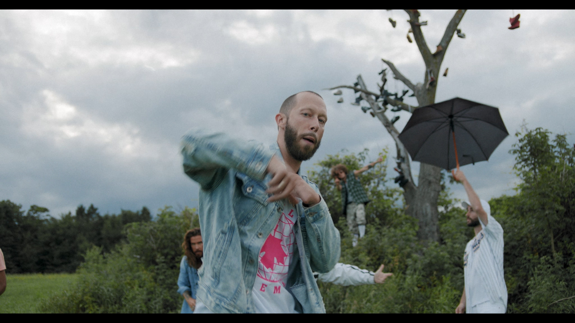 Alaclair Ensemble hip hop collective members dancing in empty field with dry tree full of shoes tied together for music video Felix filmed by Les Gamins featuring rapper Souldia