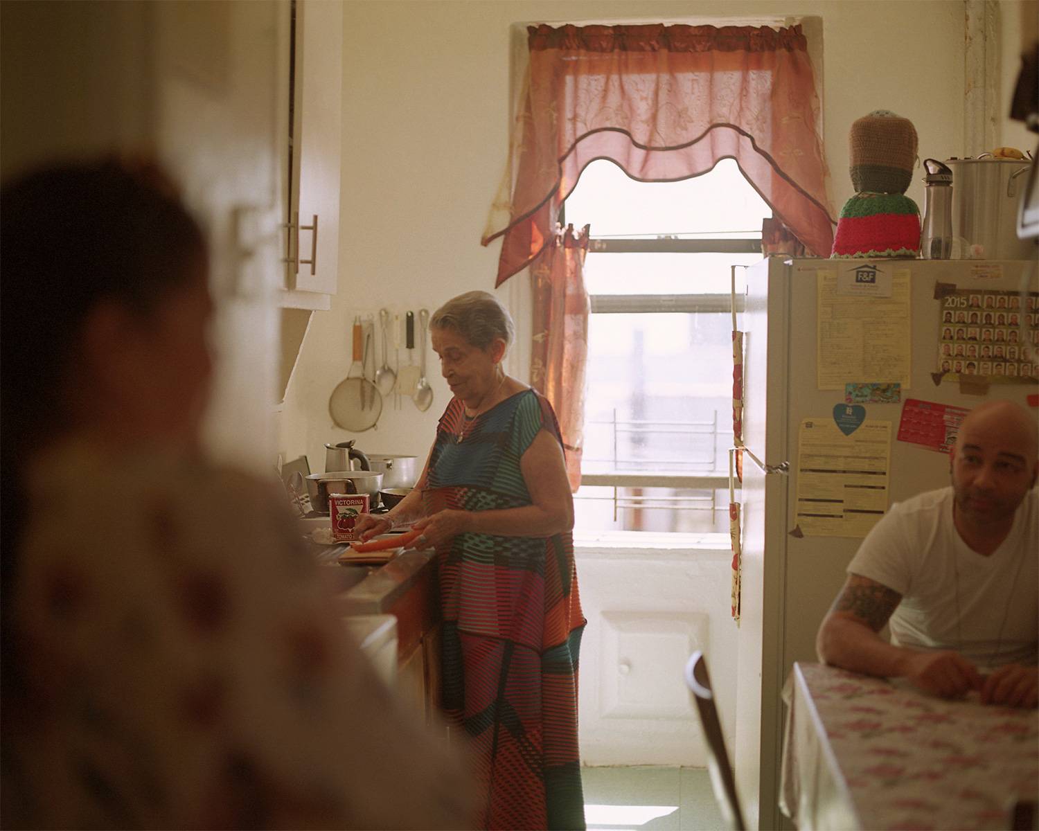 Altagracia De Pena in her kitchen with her family by Oumayma B Tanfous for Surviving the time of the butterflies article with Phosphenes Magazine
