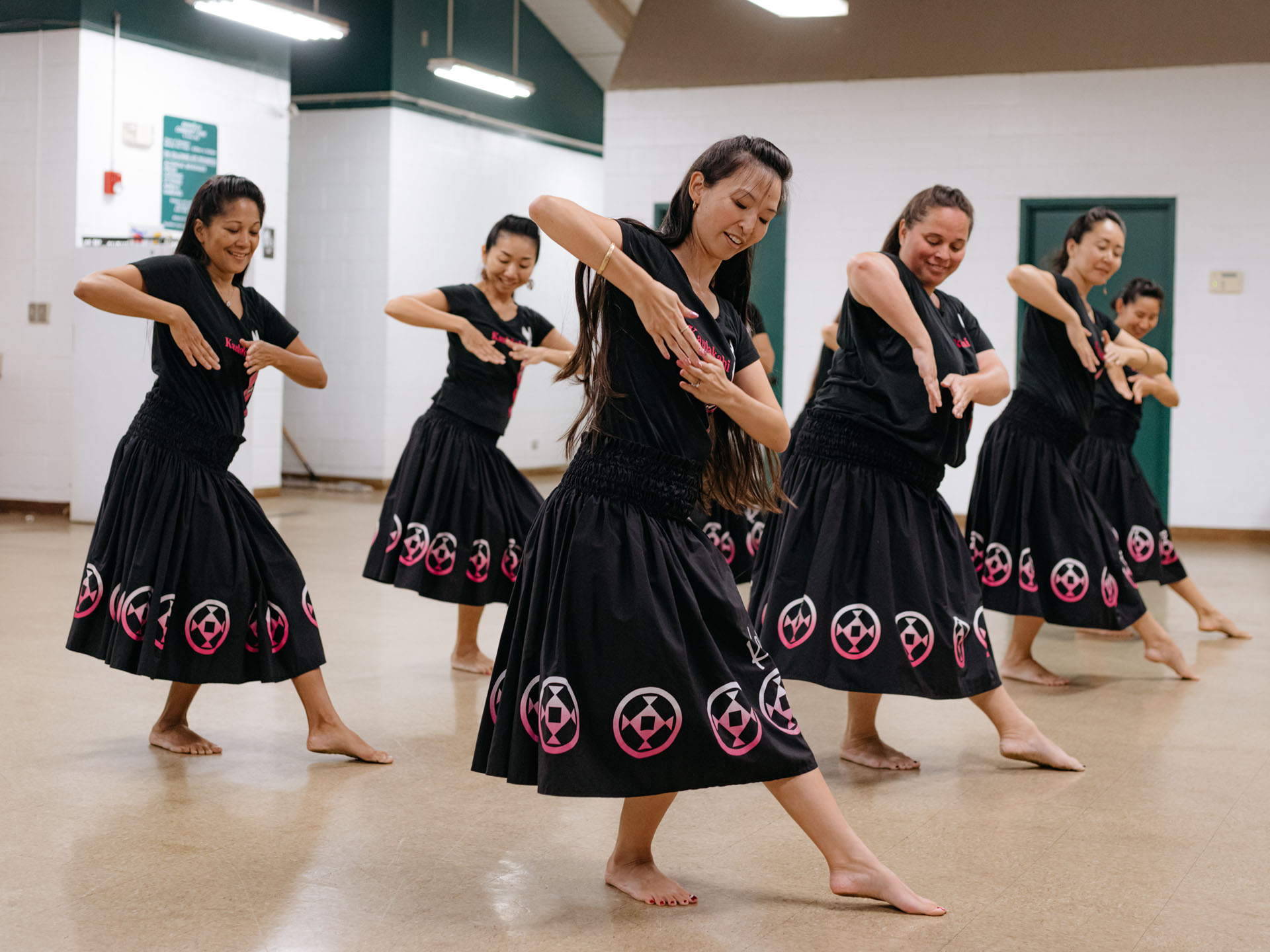 rehearsing group of traditional hula dancers by Alexi Hobbs in Hawai'i for enRoute Magazine
