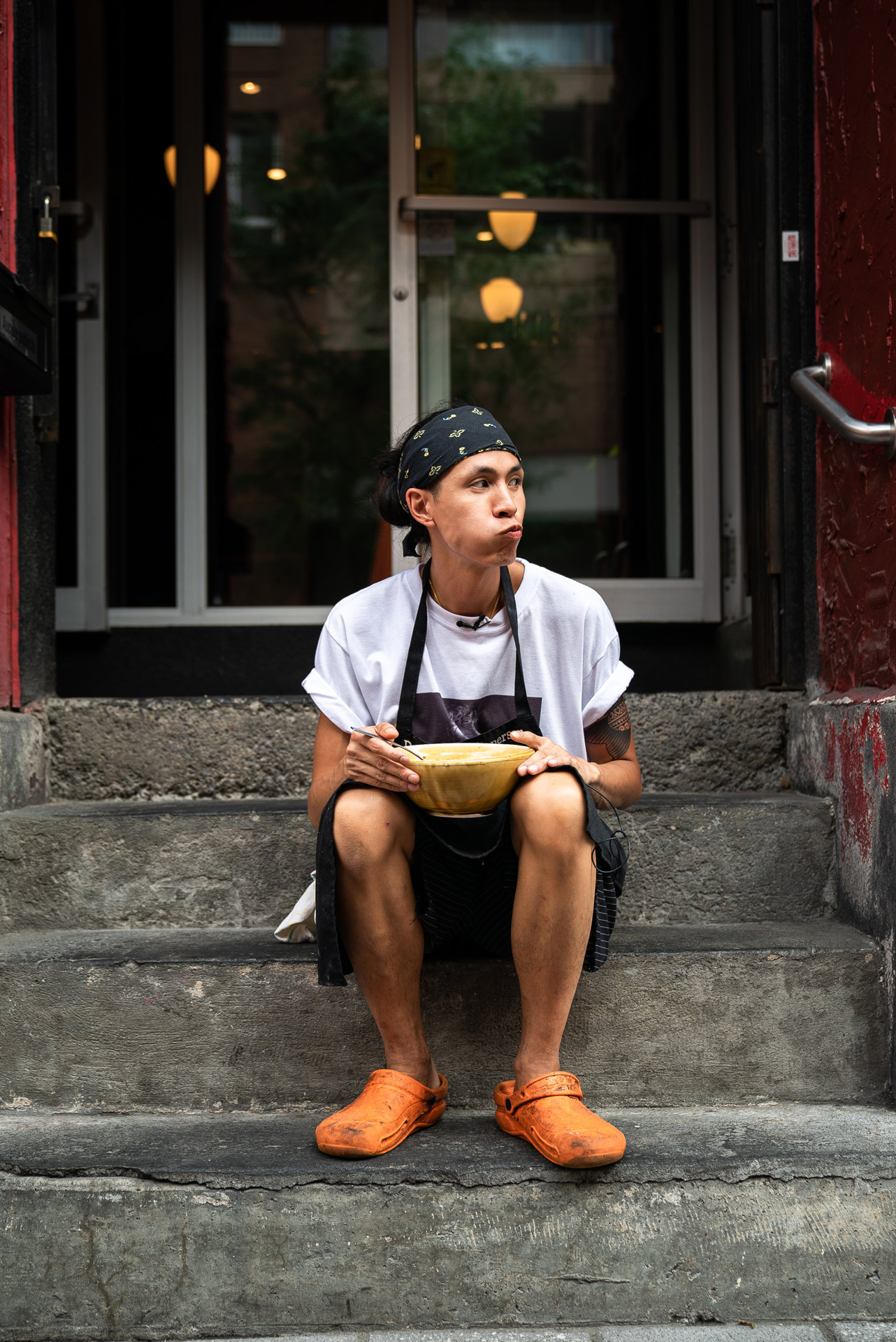 picture of chef Minh Phat Tu eating his childhood dish in front of l'Orange Rouge by Bruno Florin