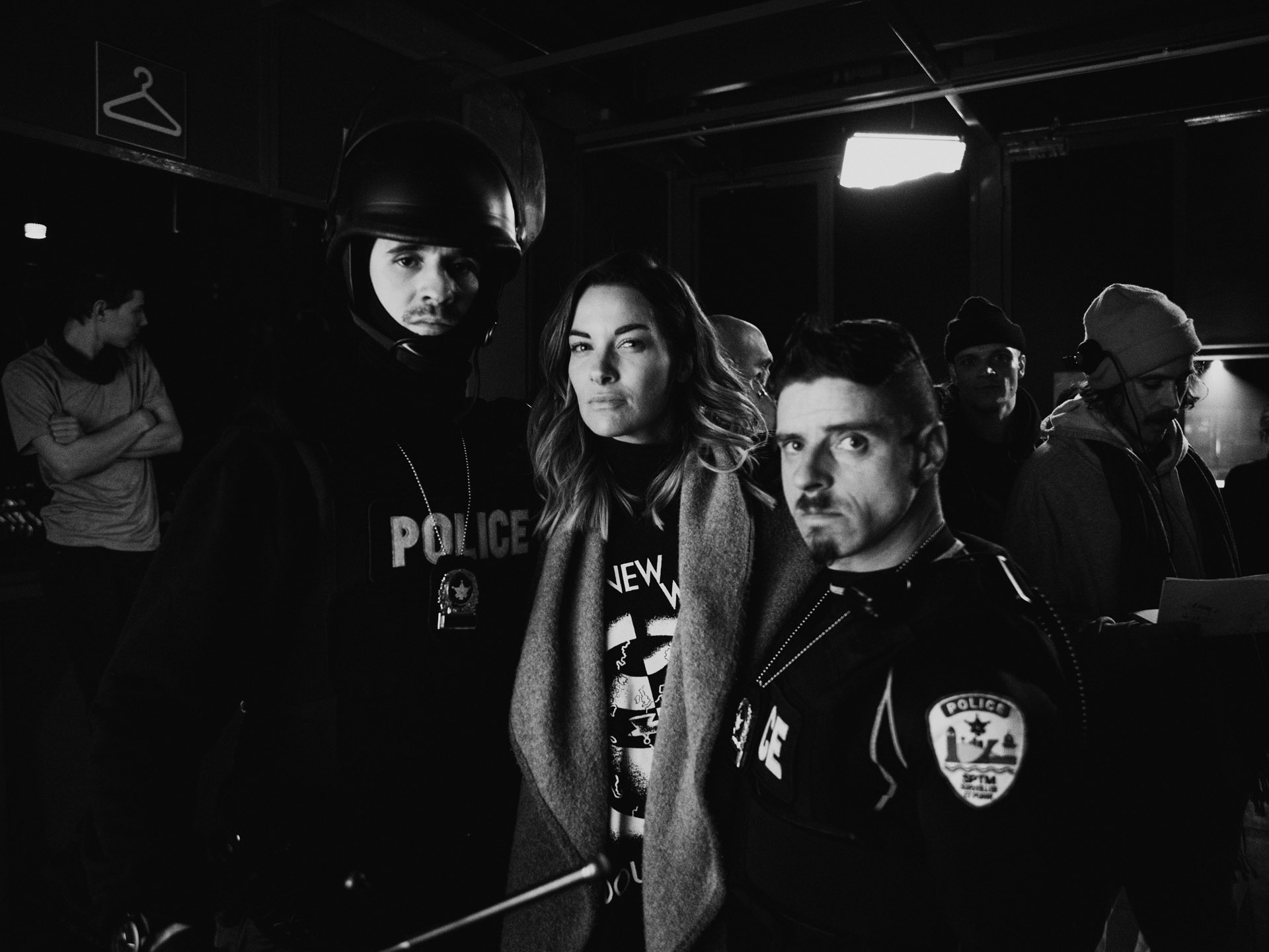 actors Hugolin Chevrette-Landesque and Emile Schneider dressed as cops posing with woman in between them in behind the scenes for TV series La Loi C'est La Loi filmed by Les Gamins for TV5 Unis