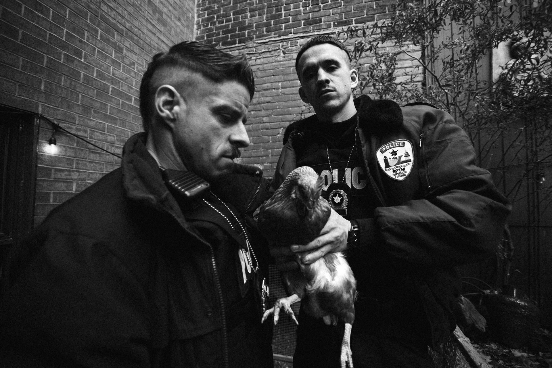 actors Hugolin Chevrette-Landesque and Emile Schneider dressed as cops holding a chicken trying to look badass in behind the scenes for TV series La Loi C'est La Loi filmed by Les Gamins for TV5 Unis