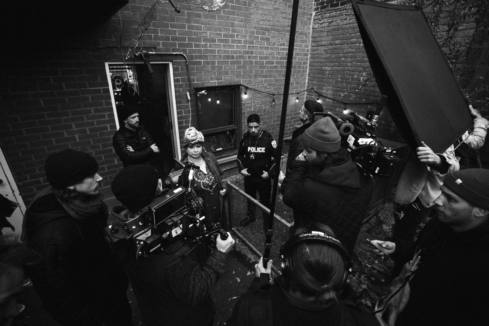 top view of shooting team with many cameras directed on actors Hugolin Chevrette-Landesque and Emile Schneider dressed as cops standing in chicken coop in behind the scenes for TV series La Loi C'est La Loi filmed by Les Gamins for TV5 Unis