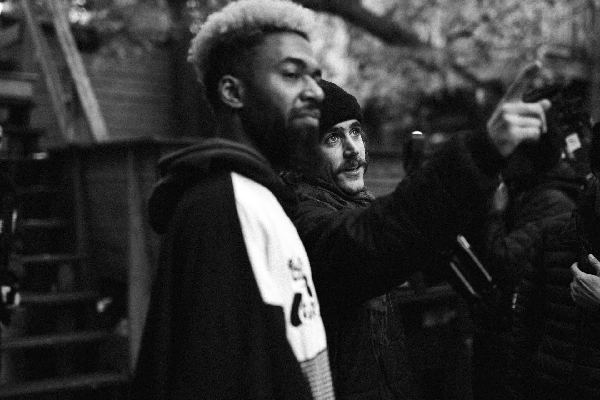 Vincent Ruel-Cote from Les Gamins giving directions to to black actor with bleached hair in behind the scenes filming TV series La Loi C'est La Loi at night with TV5 Unis