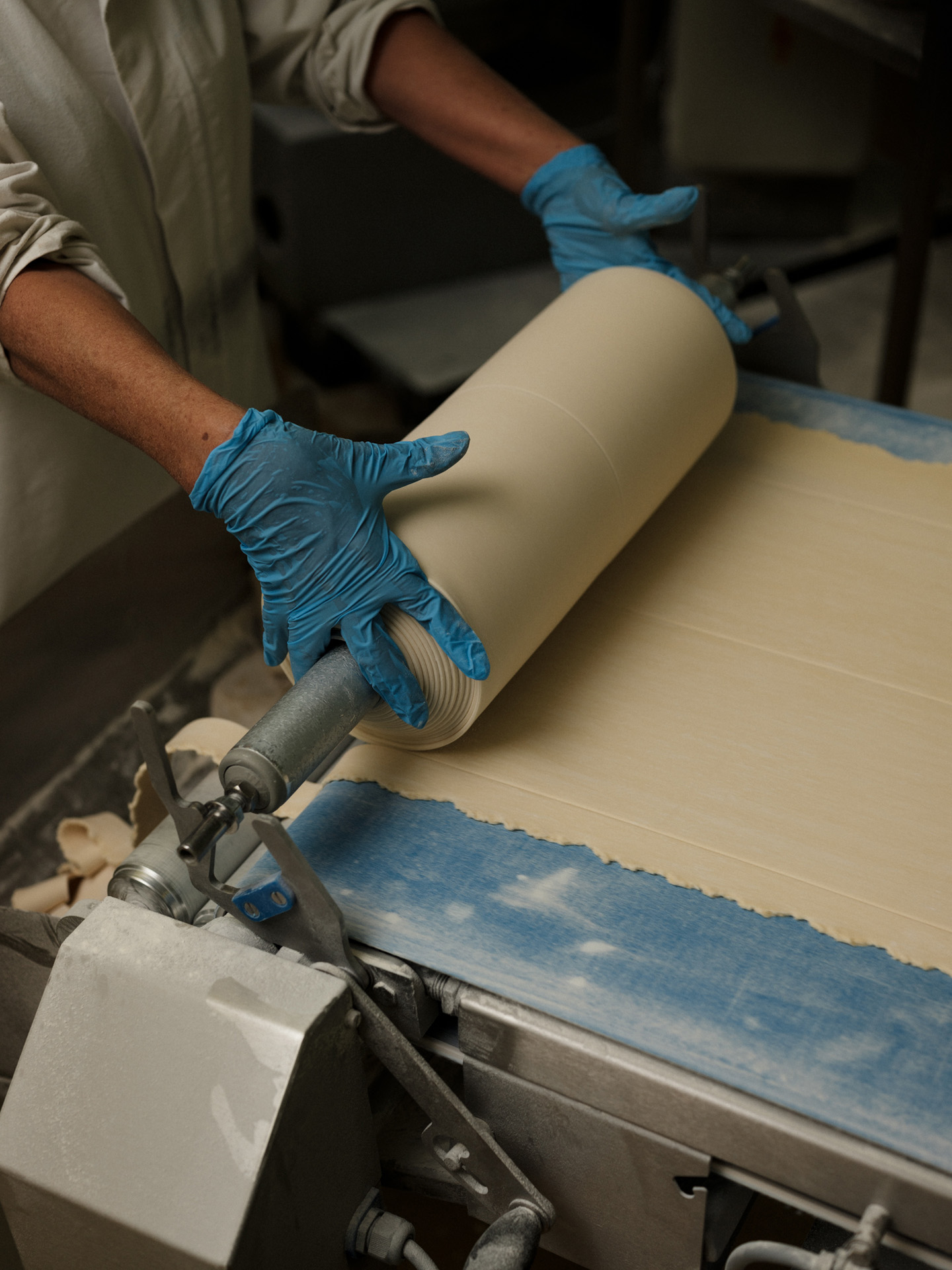 pasta doing being rolled around a pin by a worker by Alexi Hobbs in Auvergne for Reflets de France