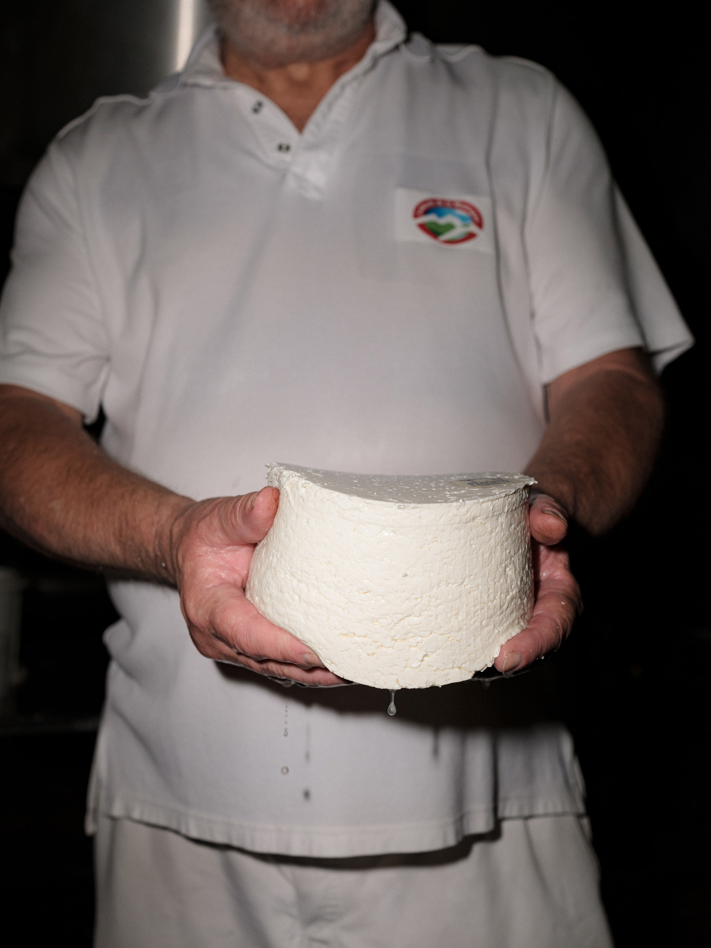 cheese maker holding freshly unmolded goat cheese by Alexi Hobbs in Auvergne for Reflets de France