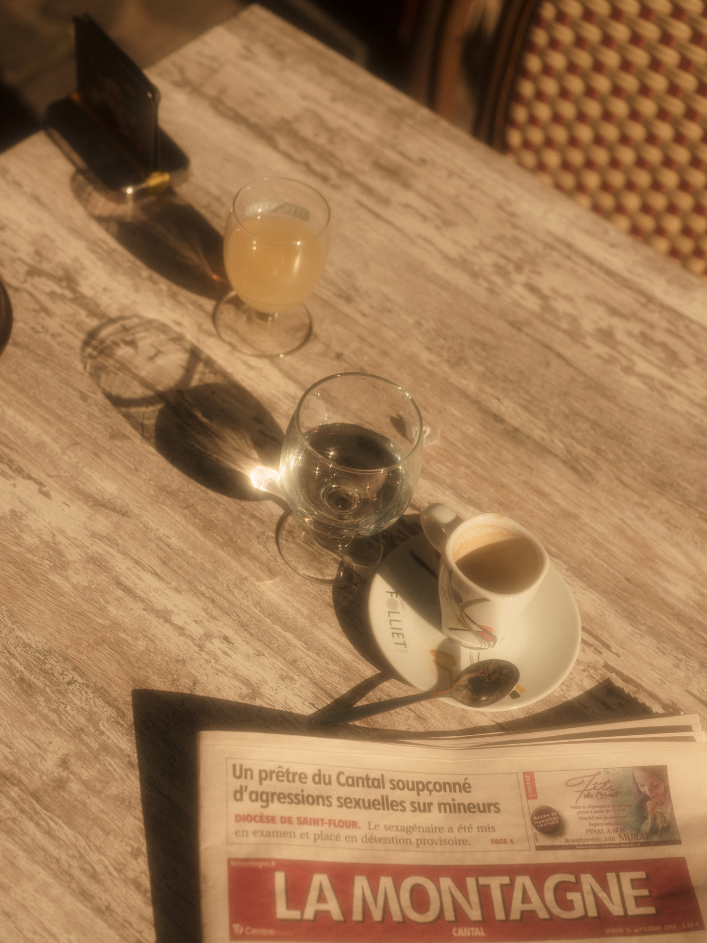 coffee wood table with empty espresso cup and glass of water by Alexi Hobbs in Auvergne for Reflets de France