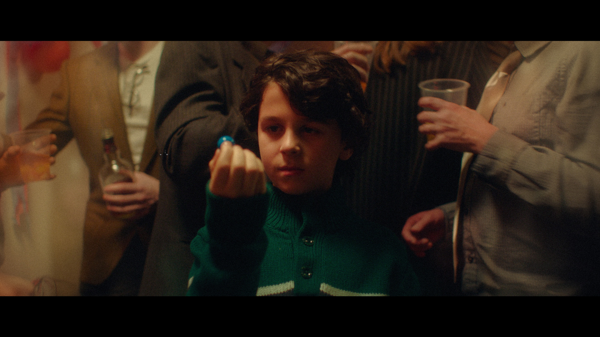 young boy holding bubblegum ball in the middle of raging party for TV series La Loi C'est La Loi filmed by Les Gamins for TV5 Unis