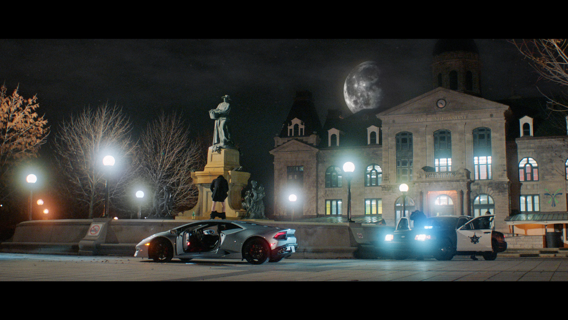 actors Hugolin Chevrette-Landesque and Emile Schneider posing as cops getting out of car to arrest a man with his pants down peeing in fountain in front of Marche Maisonneuve in Montreal for TV series La Loi C'est La Loi filmed by Les Gamins for TV5 Unis