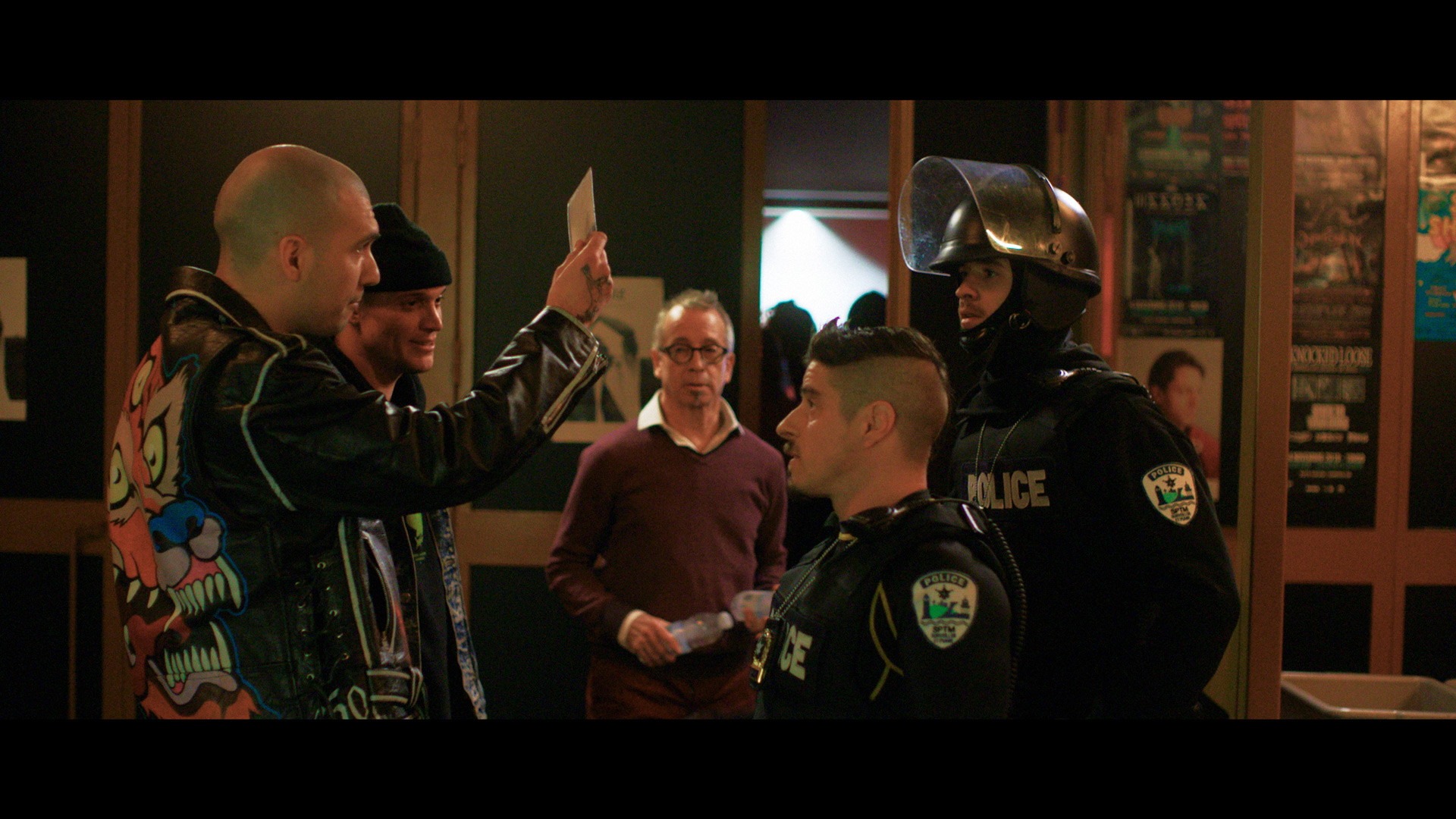 actors Hugolin Chevrette-Landesque and Emile Schneider posing as cops in front of gang members holding up a piece of paper for TV series La Loi C'est La Loi filmed by Les Gamins for TV5 Unis