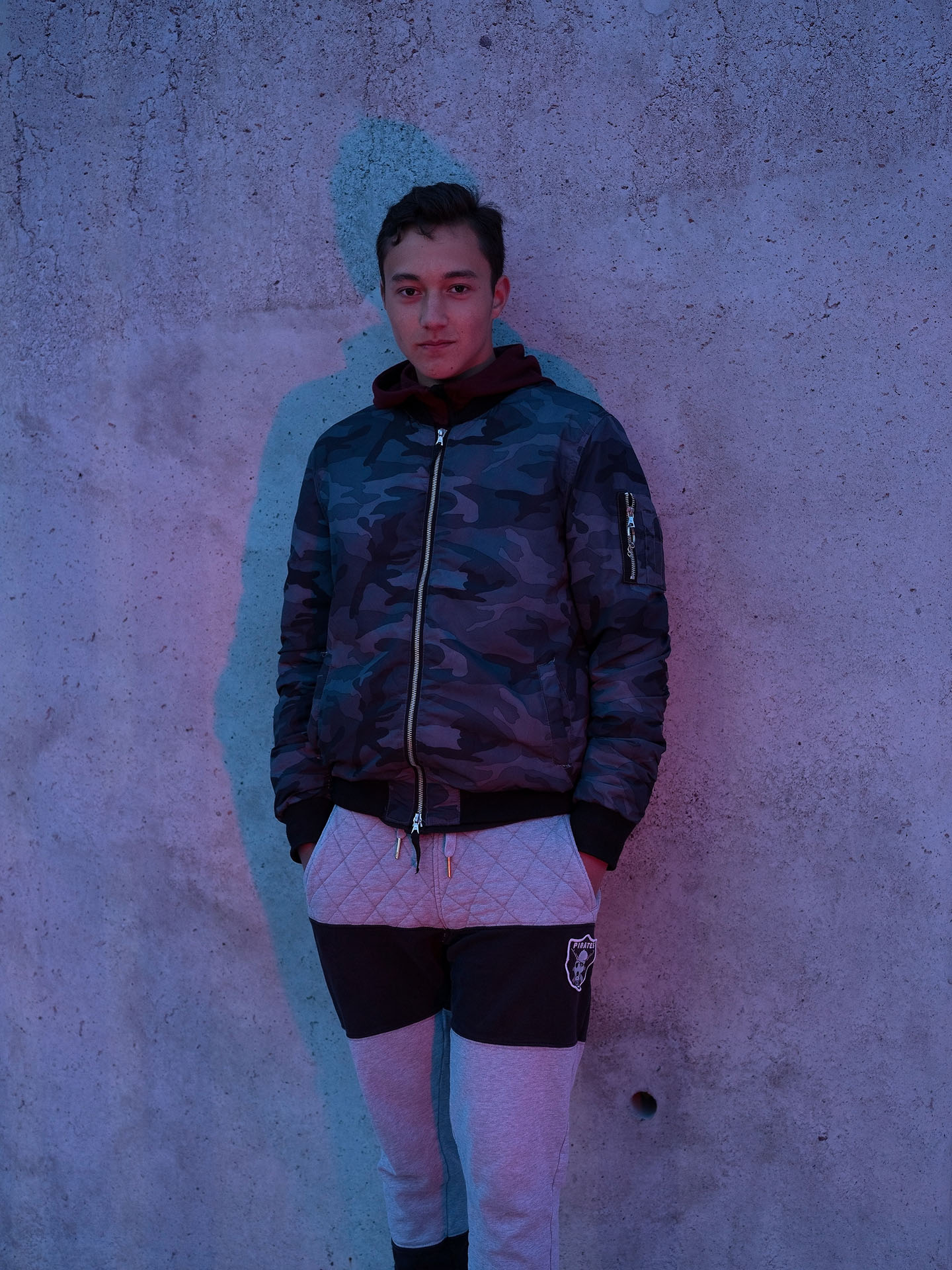 young teenage boy posing against wall in lightly red light by Guillaume Simoneau in Saint-Pierre-et-Miquelon for M le mag Le Monde