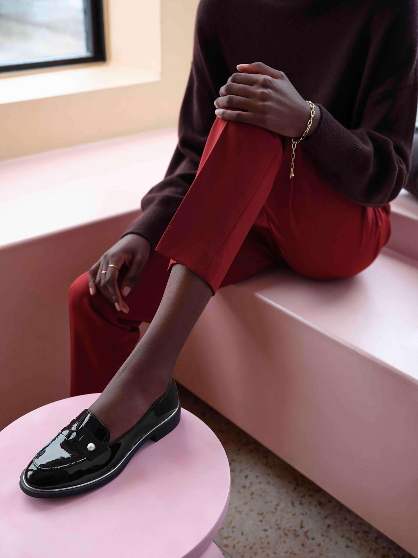 black model wearing red capri pants with oversized dark burgundy sweater and shiny black loafers by Maxyme G Delisle with artistic direction from Studio TB at Pastel Rita for Jean-Paul Fortin Fall collection