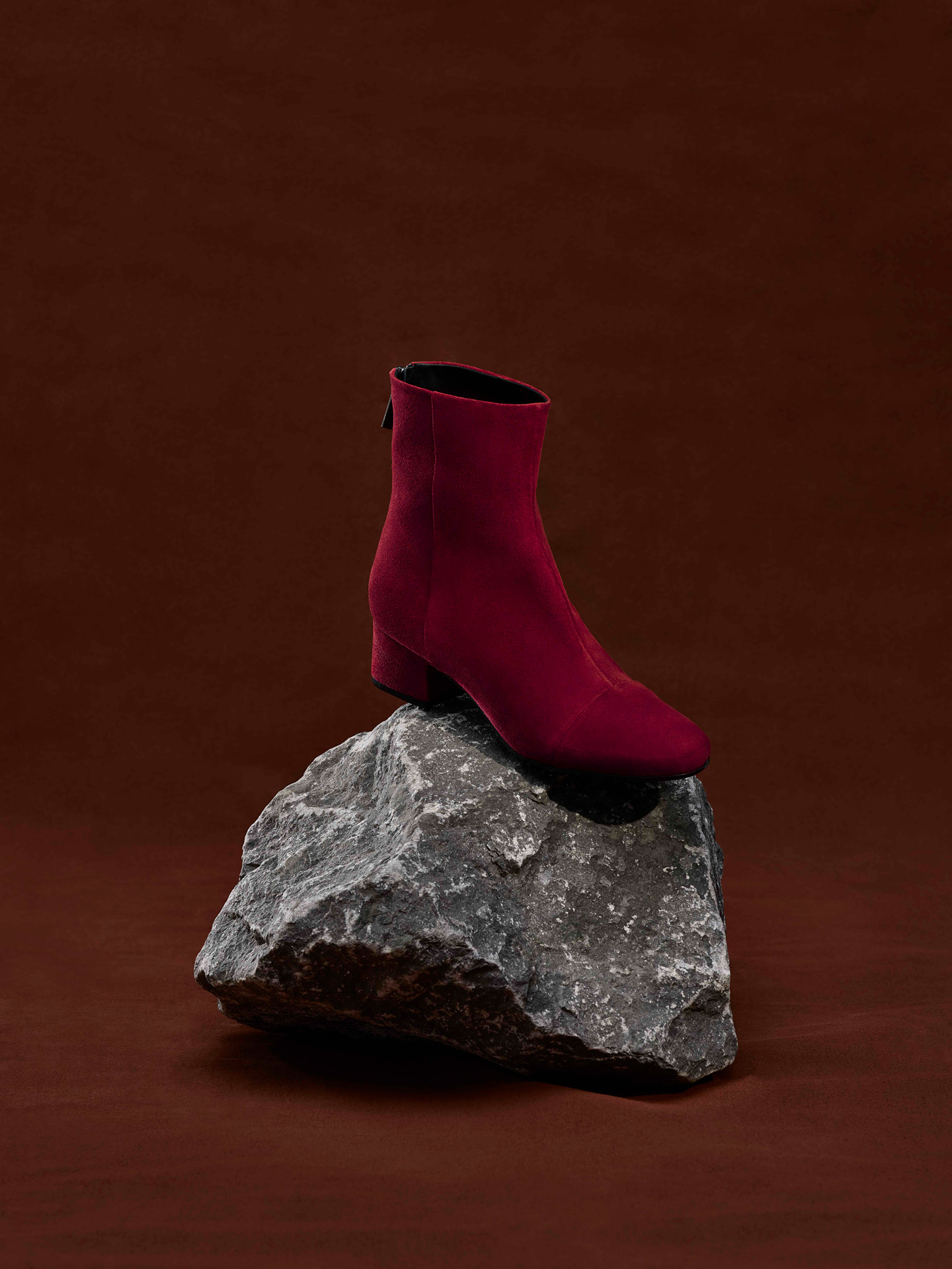 red suede boot on grey rock over red-brown background by Maxyme G Delisle with artistic direction from Studio TB for Jean-Paul Fortin Fall collection