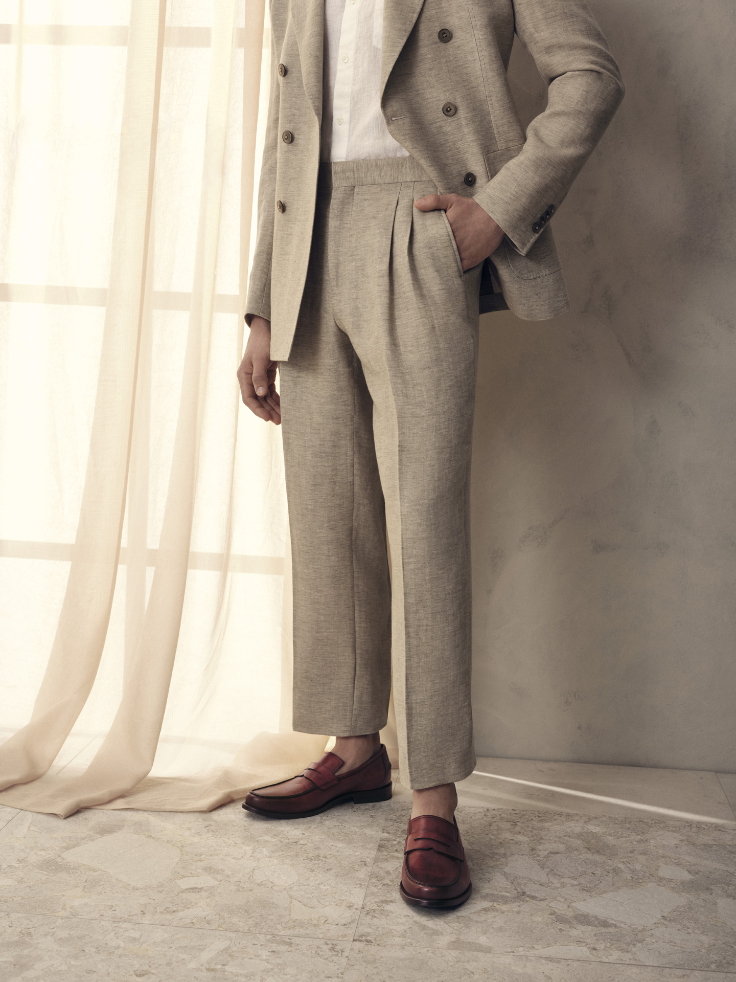 male model wearing natural colored linen suit with deep red leather loafers for Jean-Paul Fortin summer-spring collection photographed by Maxyme G Delisle with artistic direction, conception and set design by Studio TB