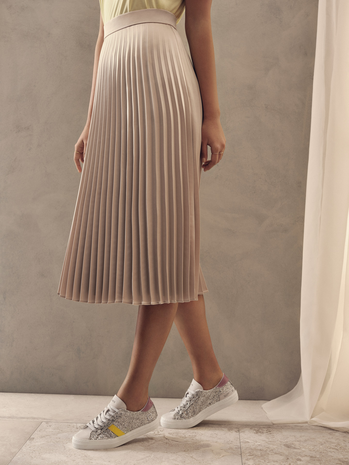 model of colour wearing pleated midi skirt with silver glitter sneakers for Jean-Paul Fortin summer-spring collection photographed by Maxyme G Delisle with artistic direction, conception and set design by Studio TB