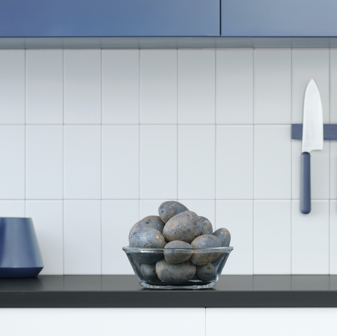 bowl of blue potatoes on grey countertops under blue cupboards in front of magnetic bleu knives by Mathieu Levesque