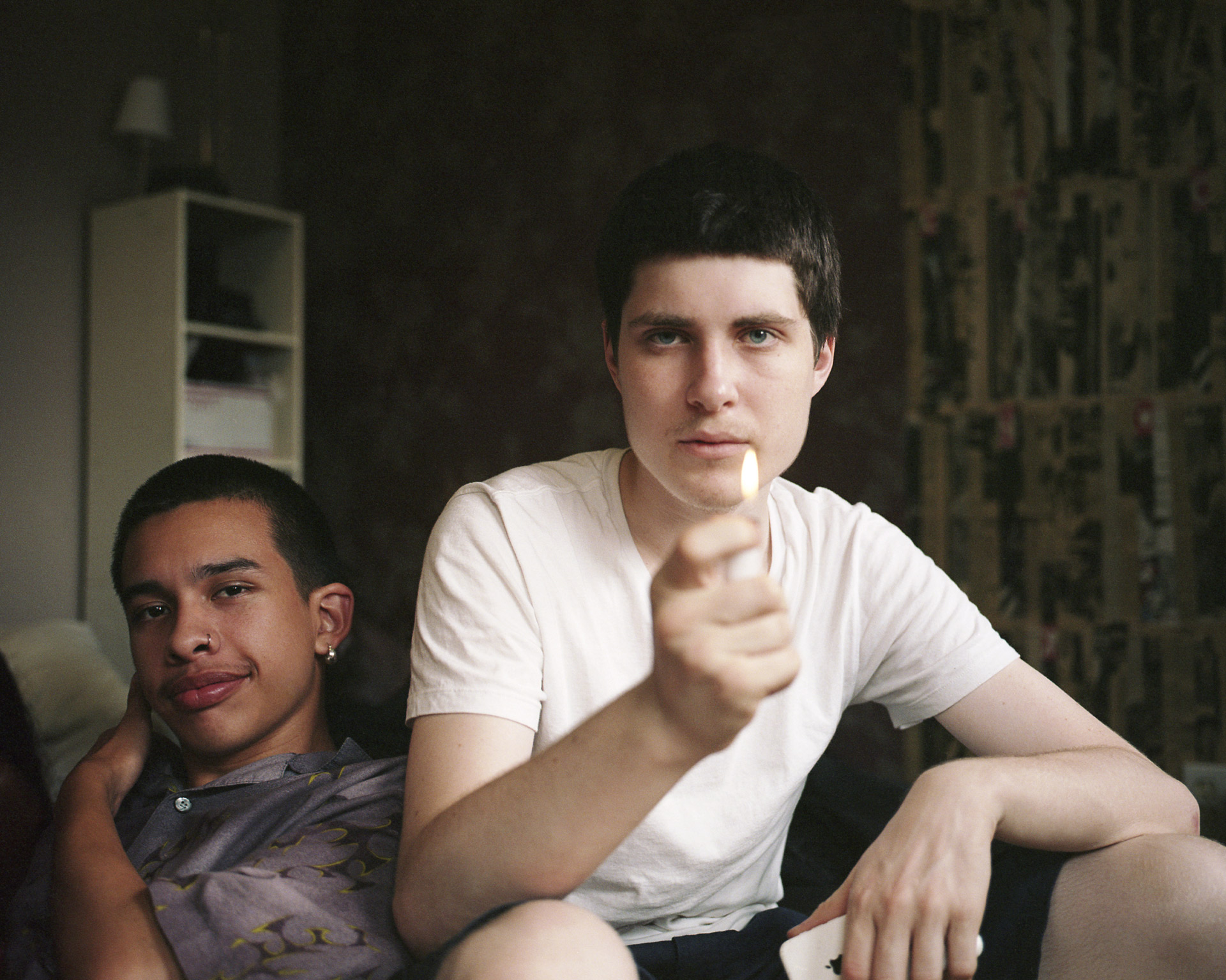 white male holding a lighter with a flame looking at camera by Oumayma B. Tanfous for DAZED