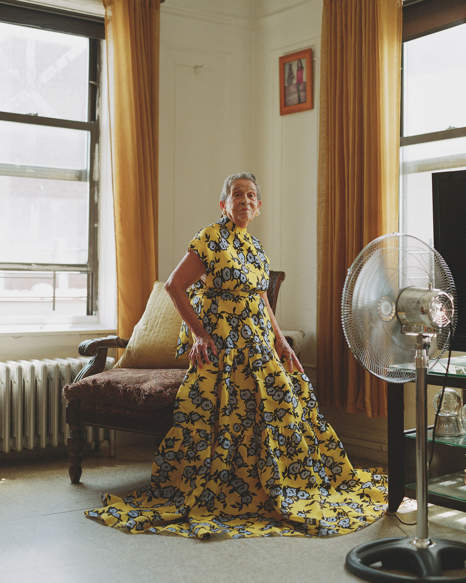 portrait of Altagracia de Pena sitting on an armchair wearing a long yellow dress by Oumayma B. Tanfous for Phosphenes Magazine