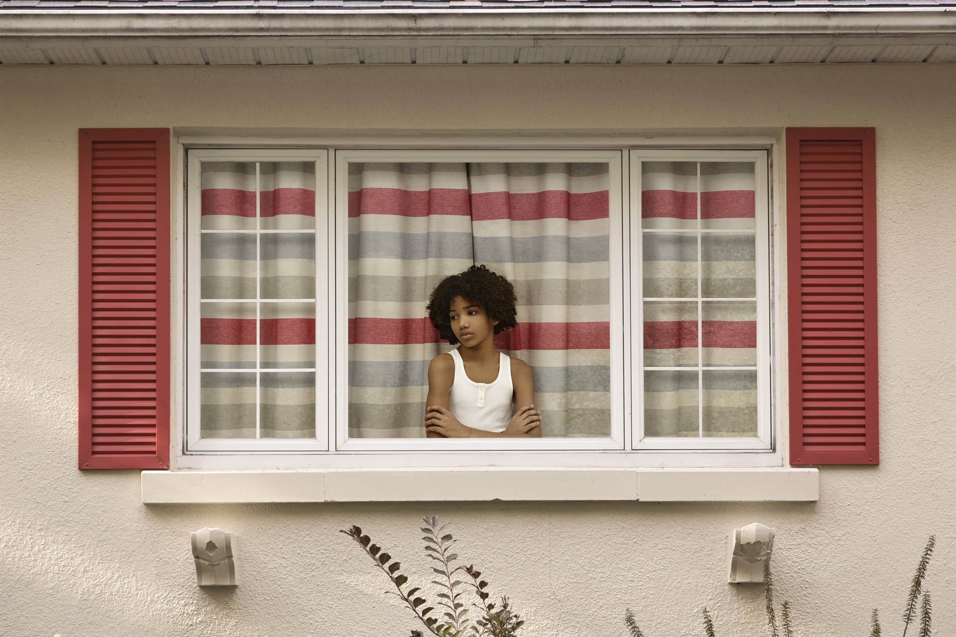 young black boy with white shirt inside house looking sadly out the window by Simon Duhamel for In Between