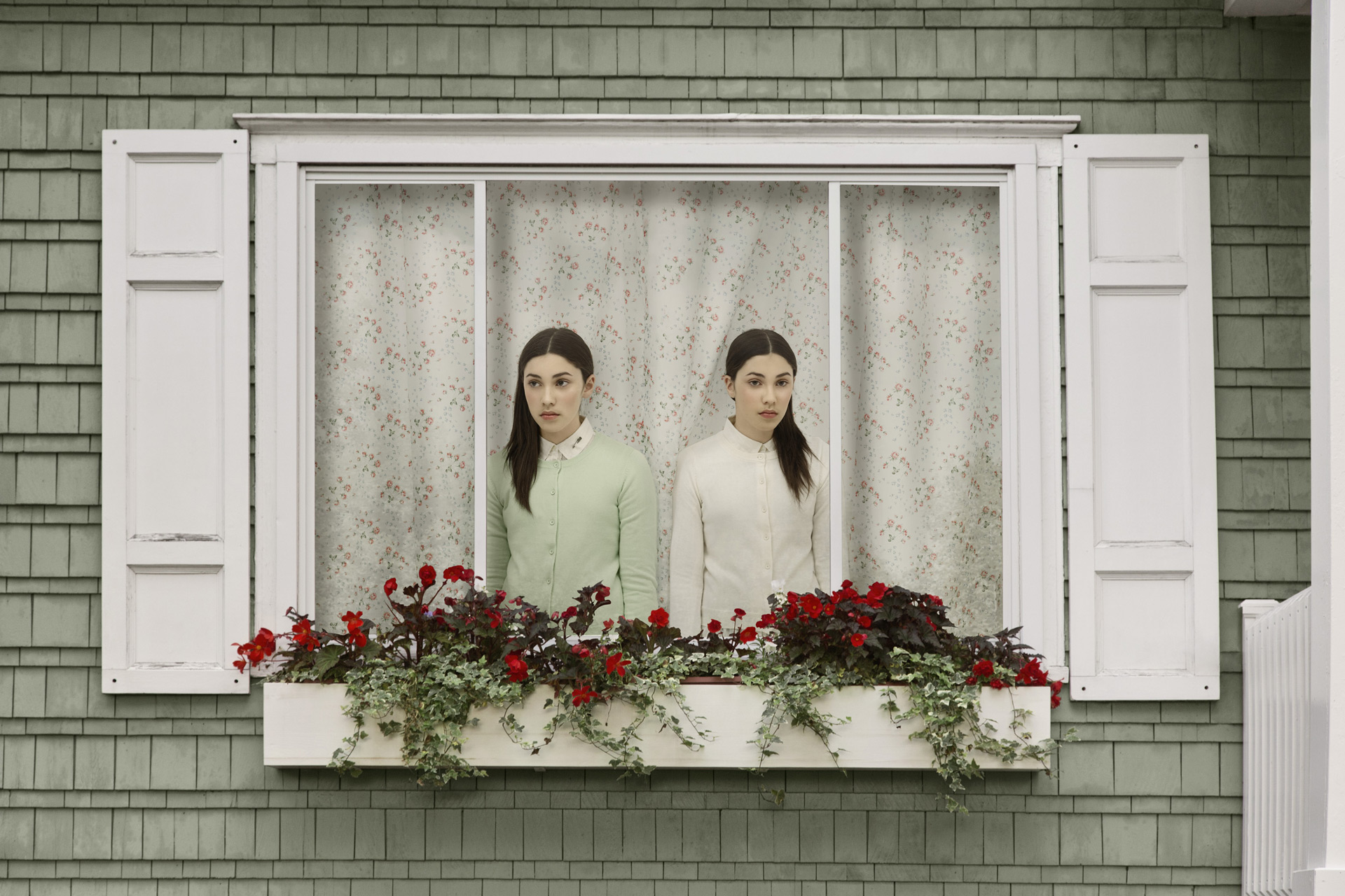 young set of twin girls one in light green one in white inside house looking sadly out the window in different directions by Simon Duhamel for In Between