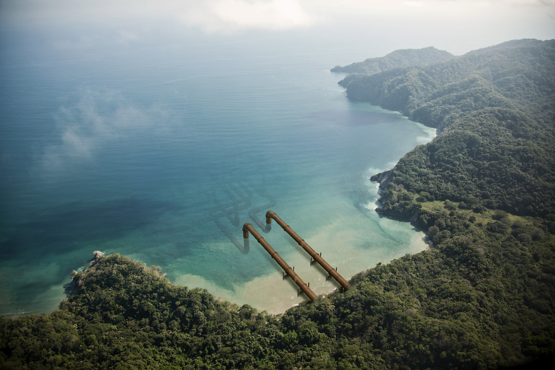 pipelines coming out of an island going into the ocean by Simon Duhamel for Pipeline