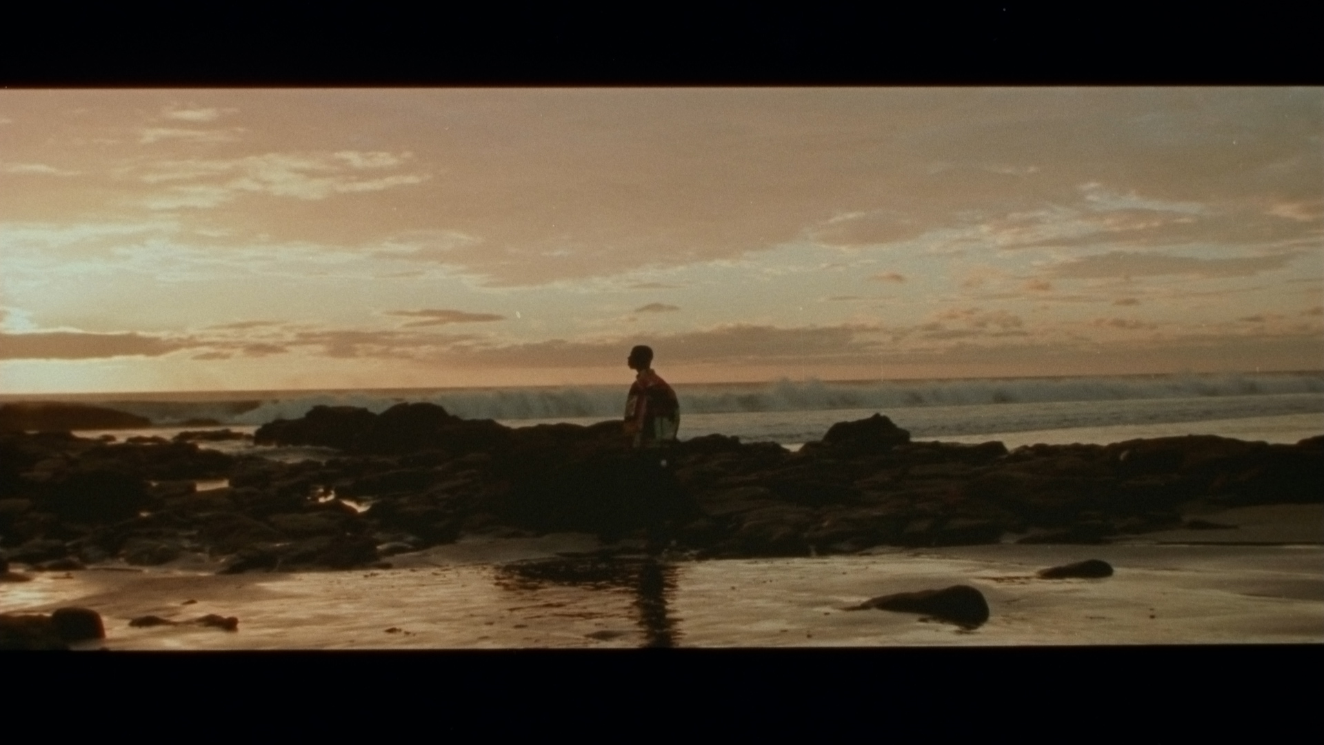 singer Karim Ouellet next to the sea at sunset for his music video of La Mer A Boire filmed by Les Gamins
