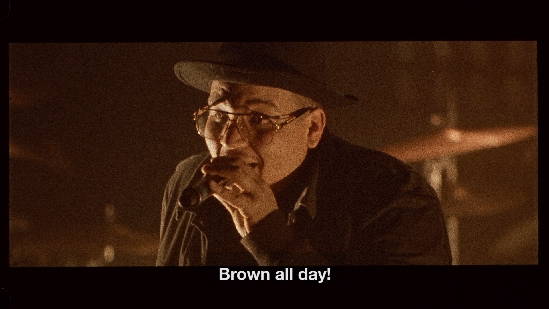 singer Brown on stage singing "Brown all day" bathed in soft orange light for L'Osstidfilm documentary filmed by Vincent Ruel-Cote from Les Gamins about L'Osstidtour