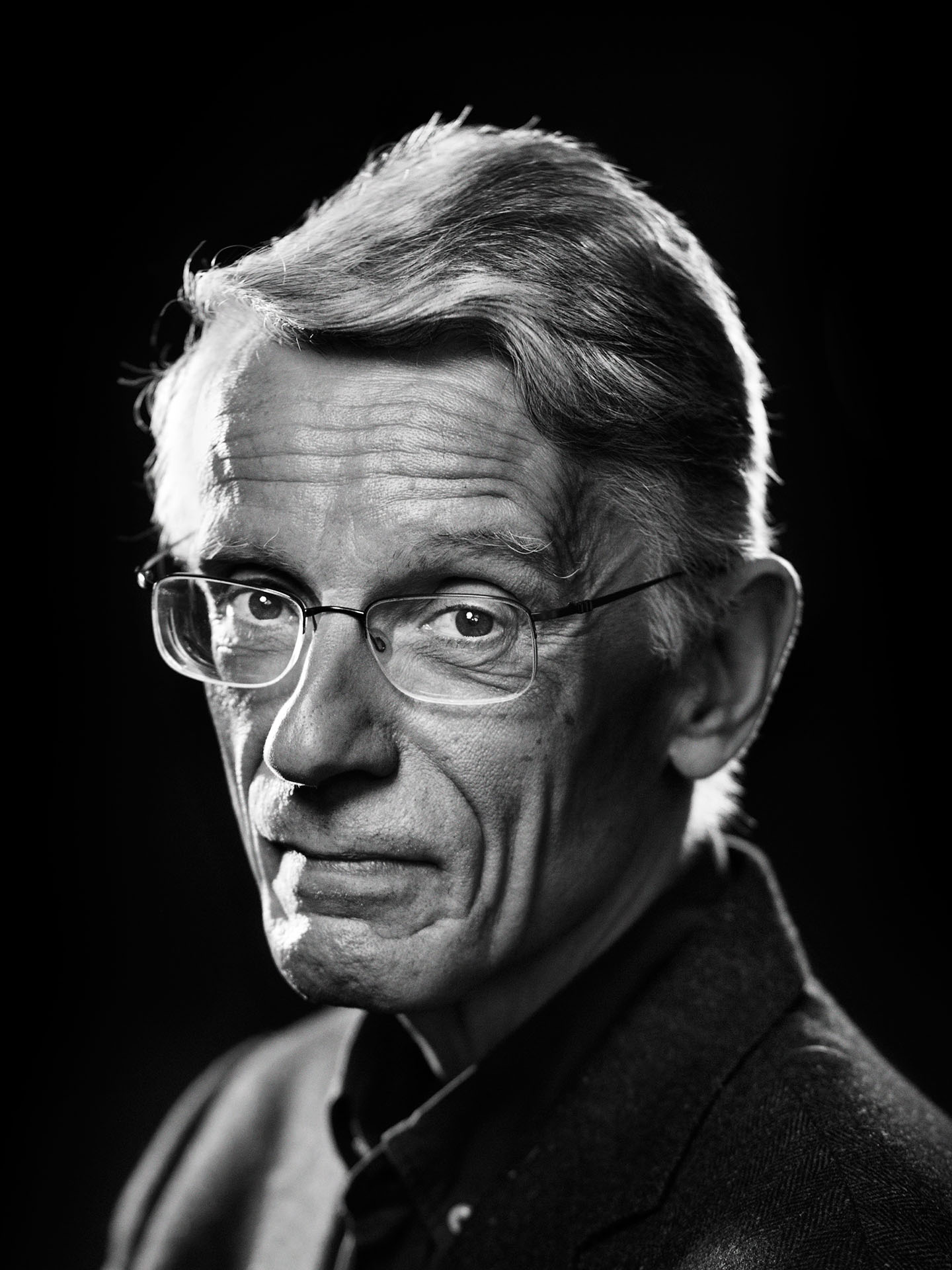 simple black and white portrait of Bernard Emond on black background by Jocelyn Michel for Voir