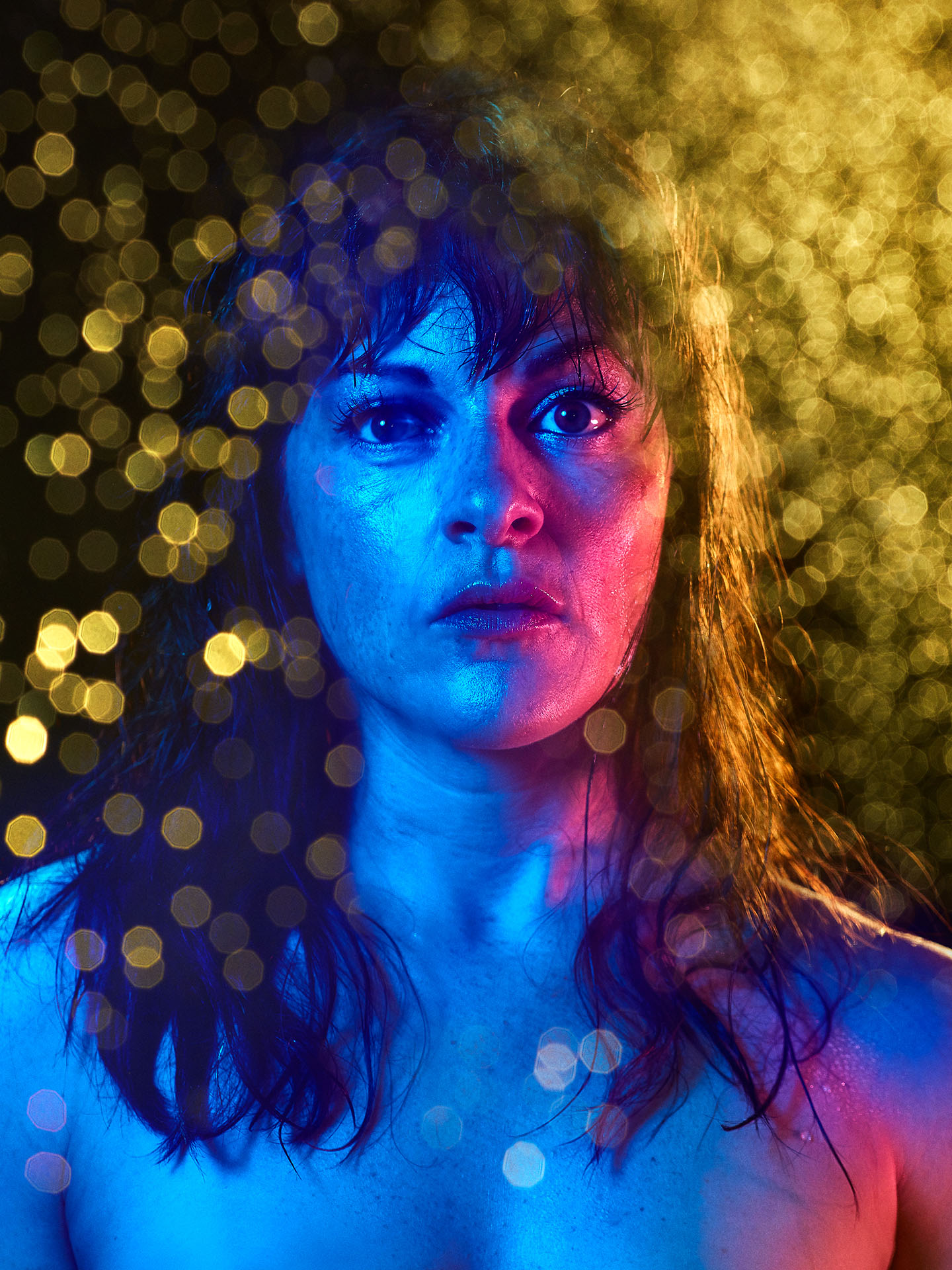 portrait of Sophie Cadieux in blue and red lighting with yellow bokeh effect on image by Jocelyn Michel for Voir